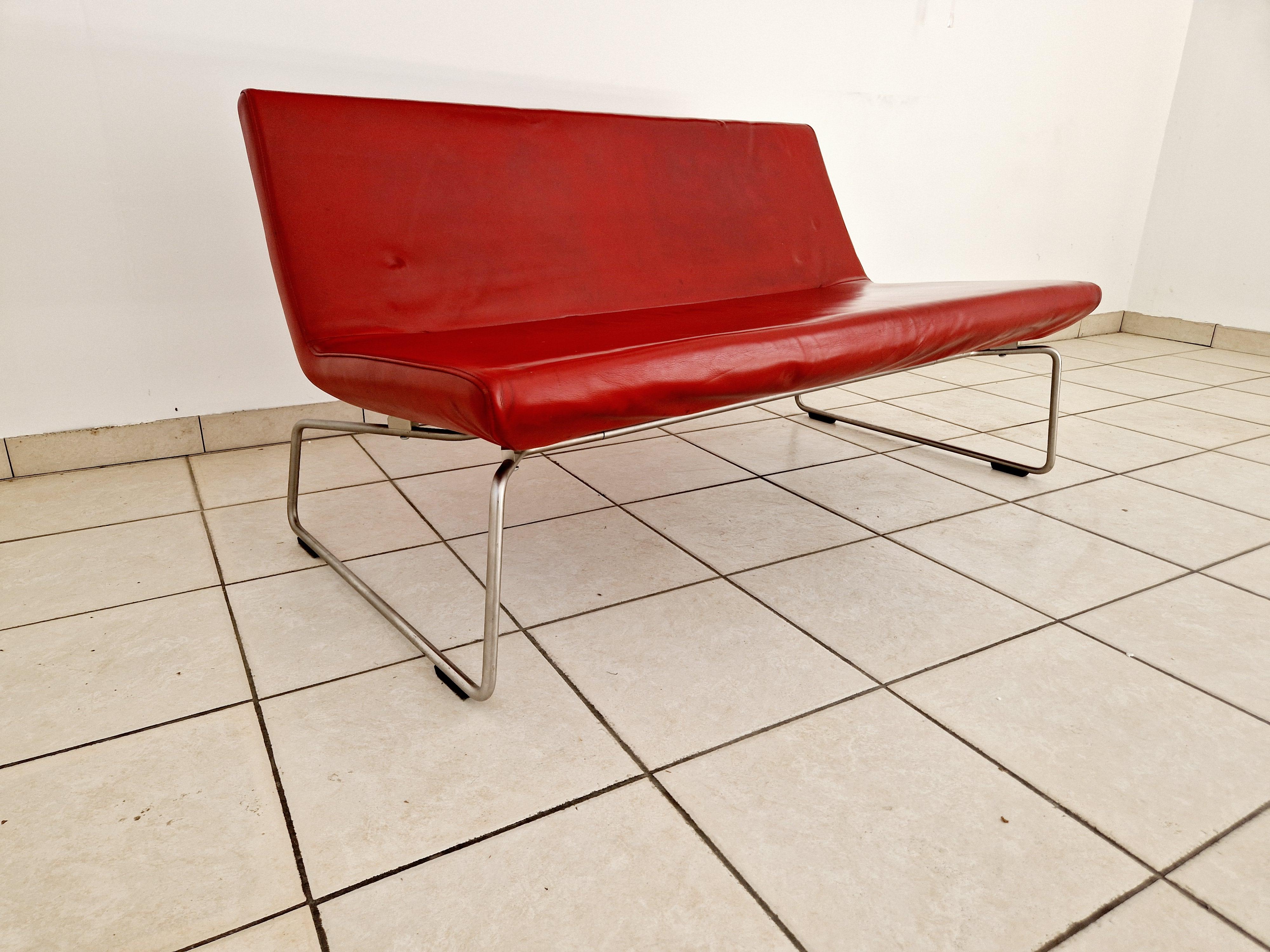 Barber e Osgerby per Cappellini, Italia, un divano Superlight a due posti, con sedute imbottite in pelle rossa e base a slitta in tondino di metallo.

Prova l'epitome dell'eleganza moderna di metà secolo con il Divano Superlight, progettato da