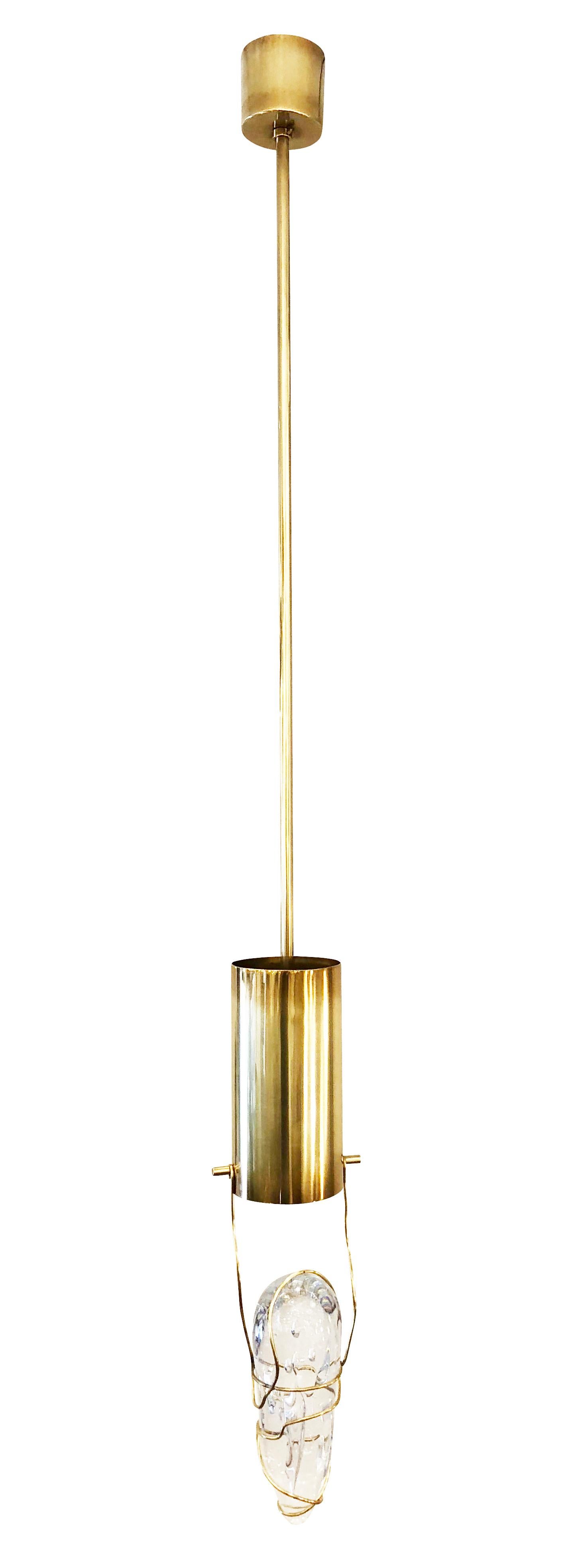 Organic modern pendant featuring a handmade glass amber wrapped in a brass cord and hung on a minimalist frame. The light projects straight into the glass creating an enchanting glow. Finish and stem length are customizable. Holds one E26 socket.