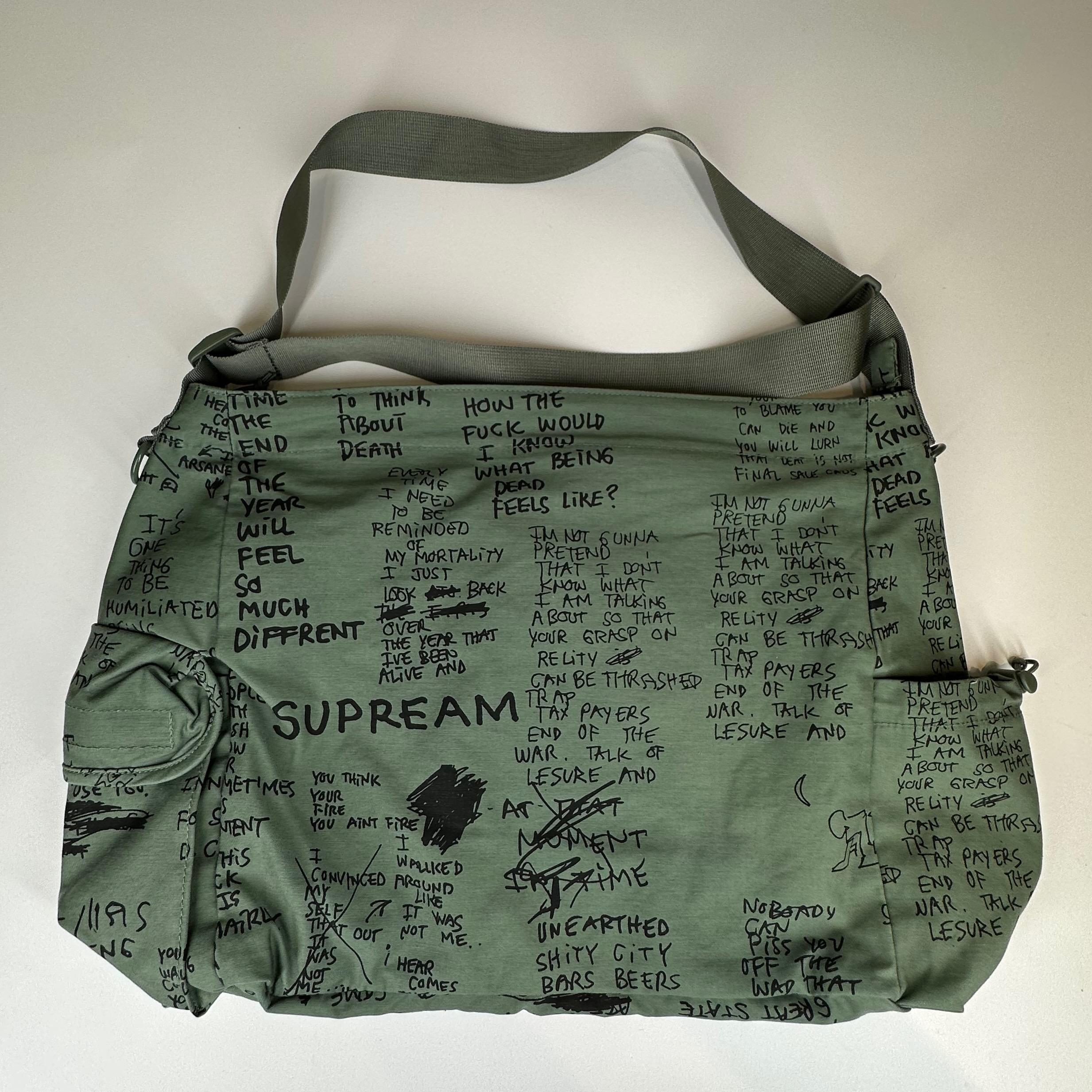 Olive Gonz Supreme Field Messenger Bag made of water resistant cotton and nylon blend fabric with embossed logo lining. Zipped main compartment, internal zip and kangaroo pockets. Additional zipped pockets on the front. Velcro flap and side water