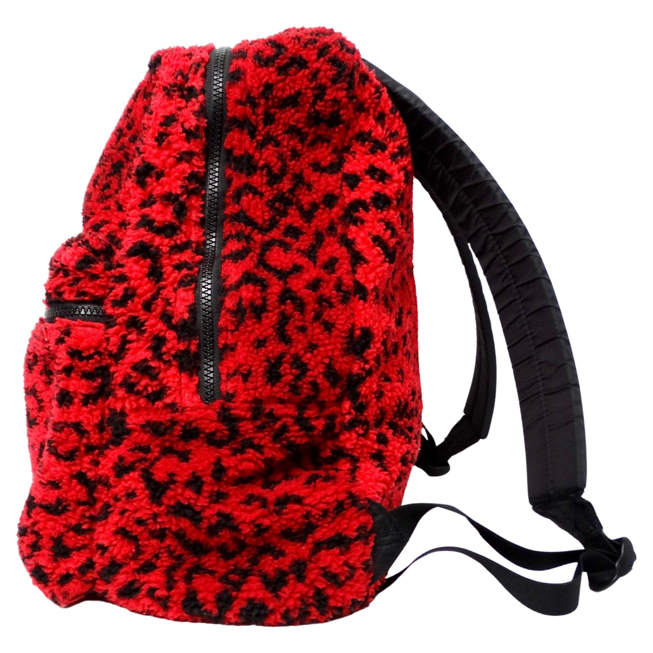 The Supreme Red & Black Leopard Print Fleece Backpack from circa 2017 is a bold and eye-catching accessory that seamlessly combines streetwear edge with luxury appeal. Crafted from plush fleece material, the backpack features a striking red and