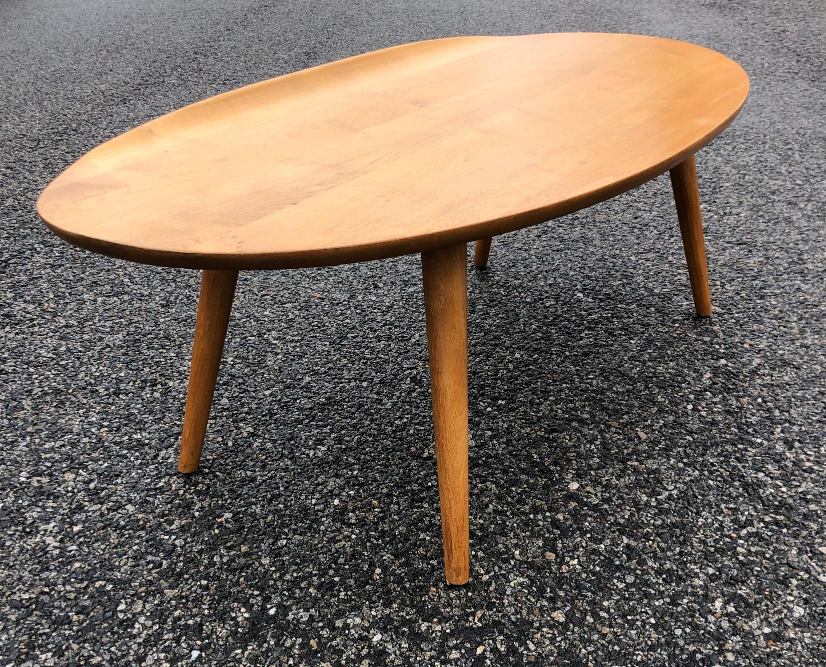 A wonderful and play on the surfboard. Oval shaped coffee table with a raised edge. Made from solid maple. Designed by the famous architect Russel Wright. In original condition A cool addition to any home.