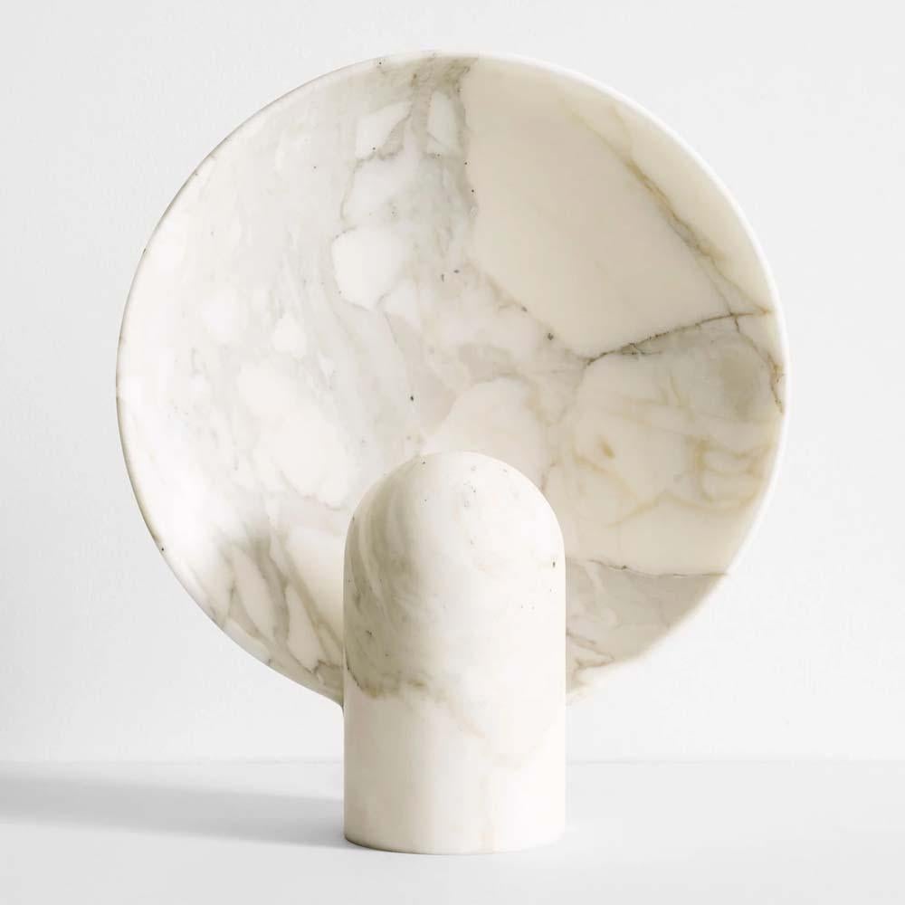 A Calacatta marble table lamp full of elegance and softness.

The surface sconce in Calacatta Marble is an ambient, sculptural light carved in two halves from solid stone. The European marble is made in Porto (Portugal). This clear calacatta