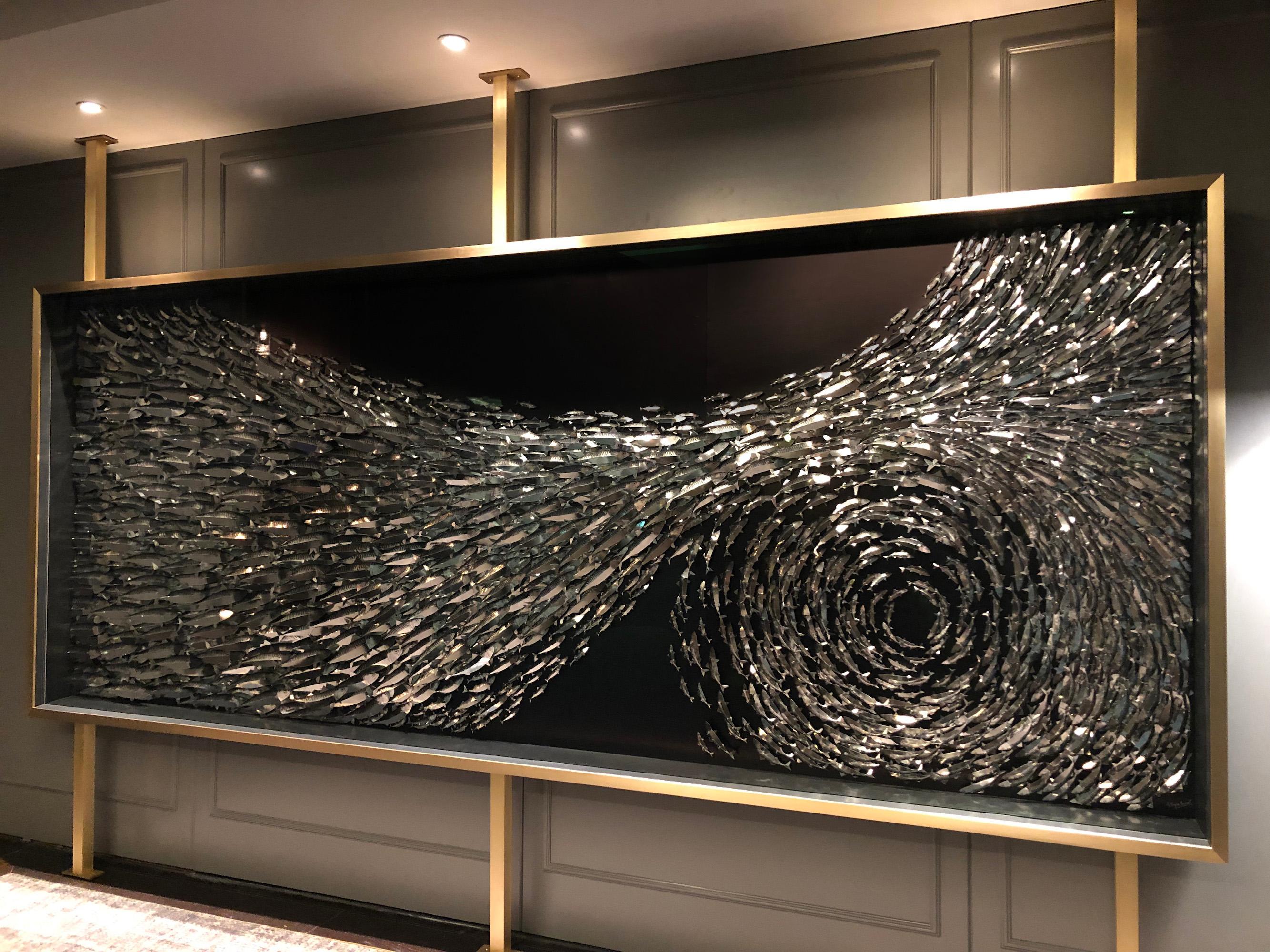 This unique and arresting piece captures the rush of energy and movement as a shoal of 1,000 mackerel switches direction, their silver bellies flashing in the sunlight. Each fish is fabricated by hand in robust paper-based materials with a metallic