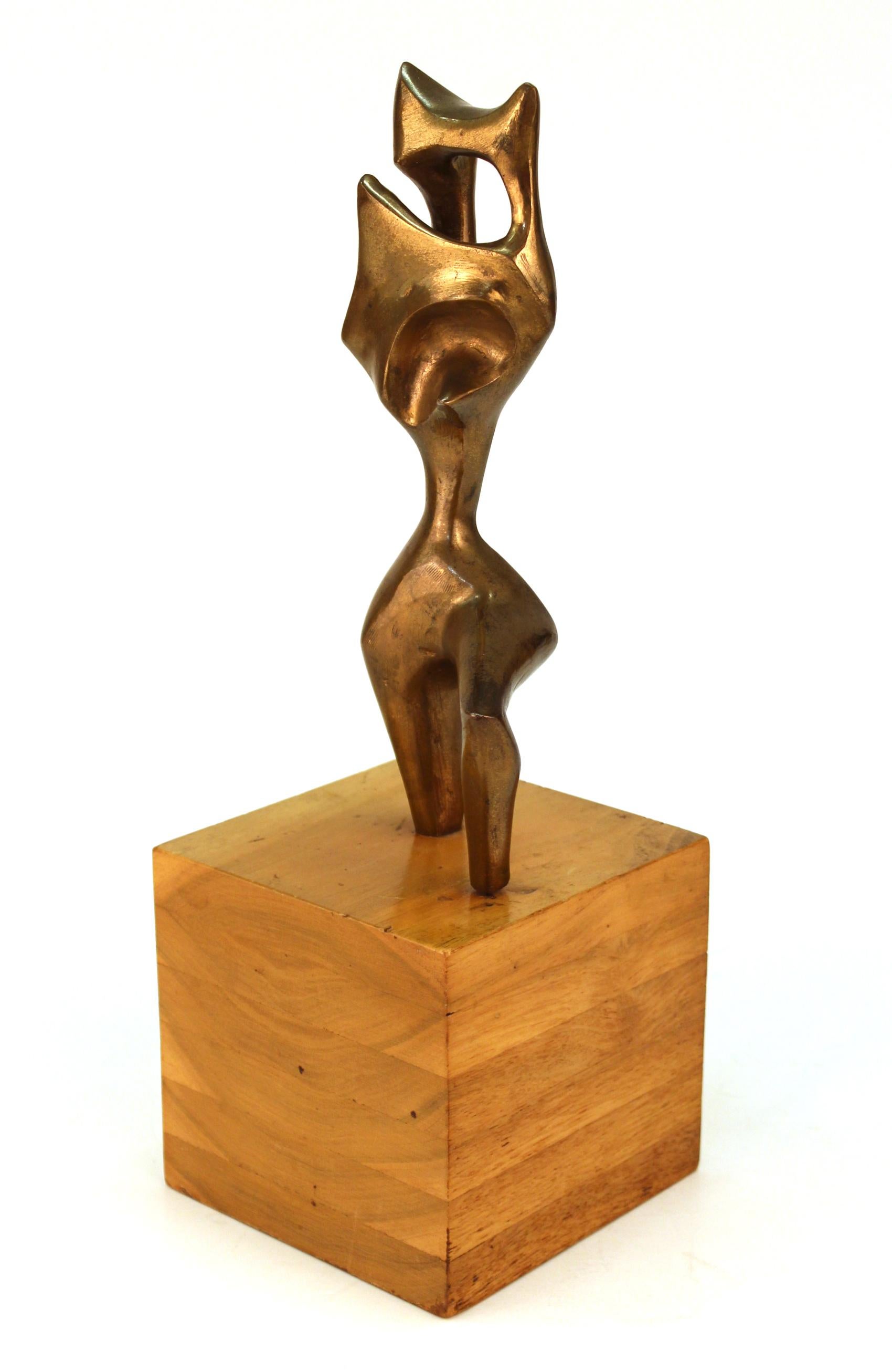 Surrealist abstract sculpture in patinated bronze in the manner of Wifredo Lam or Yves Tanguy. The sculpture depicts an abstract figure on one knee, atop a wooden cube base and is marked 'W' and numbered. Created in the United States in the