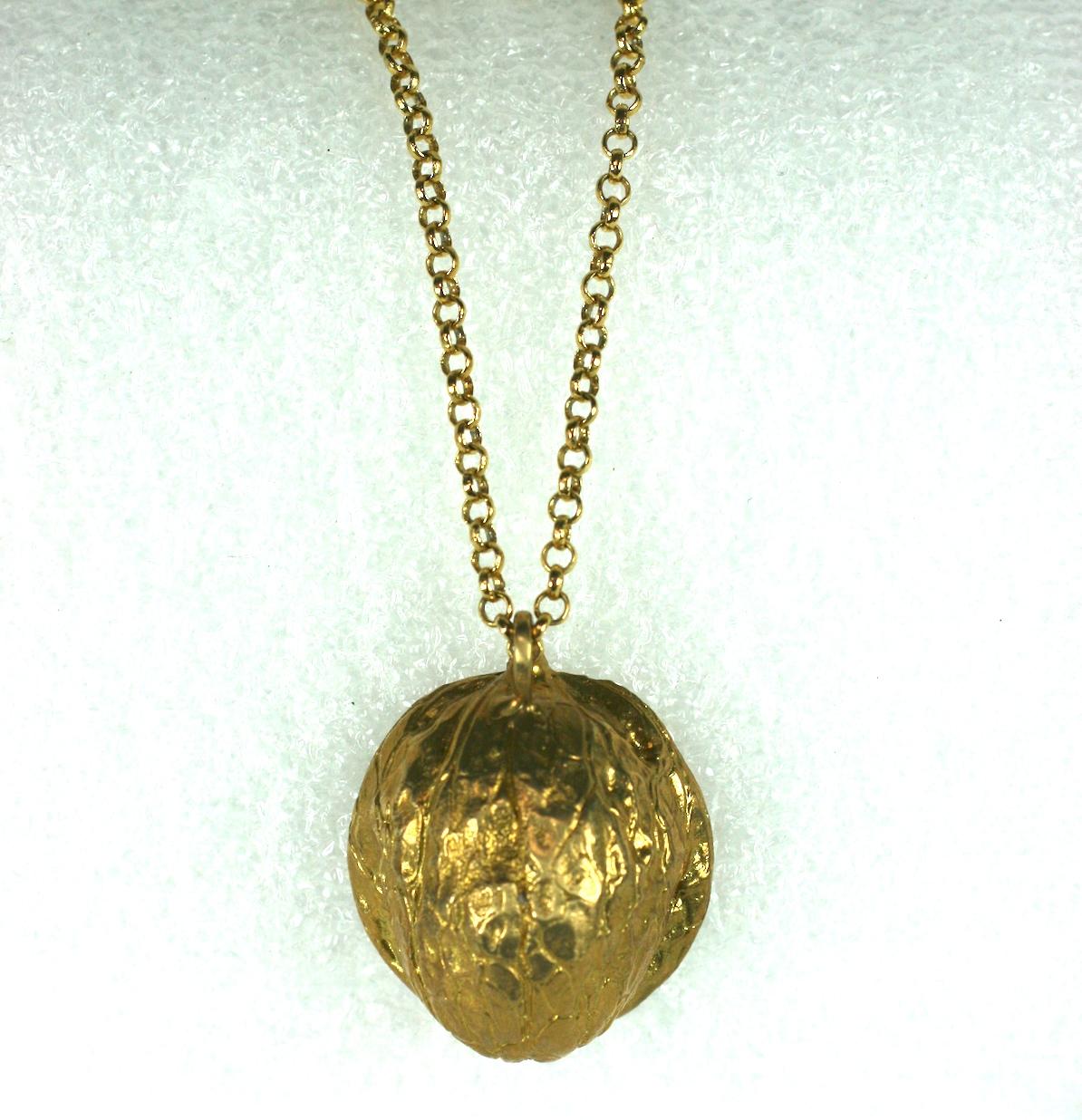 Surrealist Art Nouveau style pendant in a half walnut form with a woman's face within. Can be worn with the walnut shell out or with the face visible. 
Appears to be gilded bronze. European circa 1940's.
Chain 25