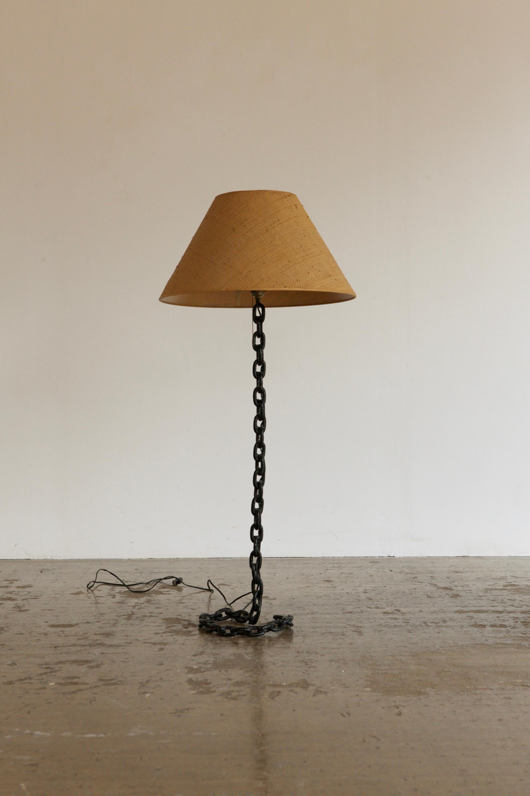 1980's floor lamp with a surrealist metal chain base and woven hemp shade. In the manner of Franz West.