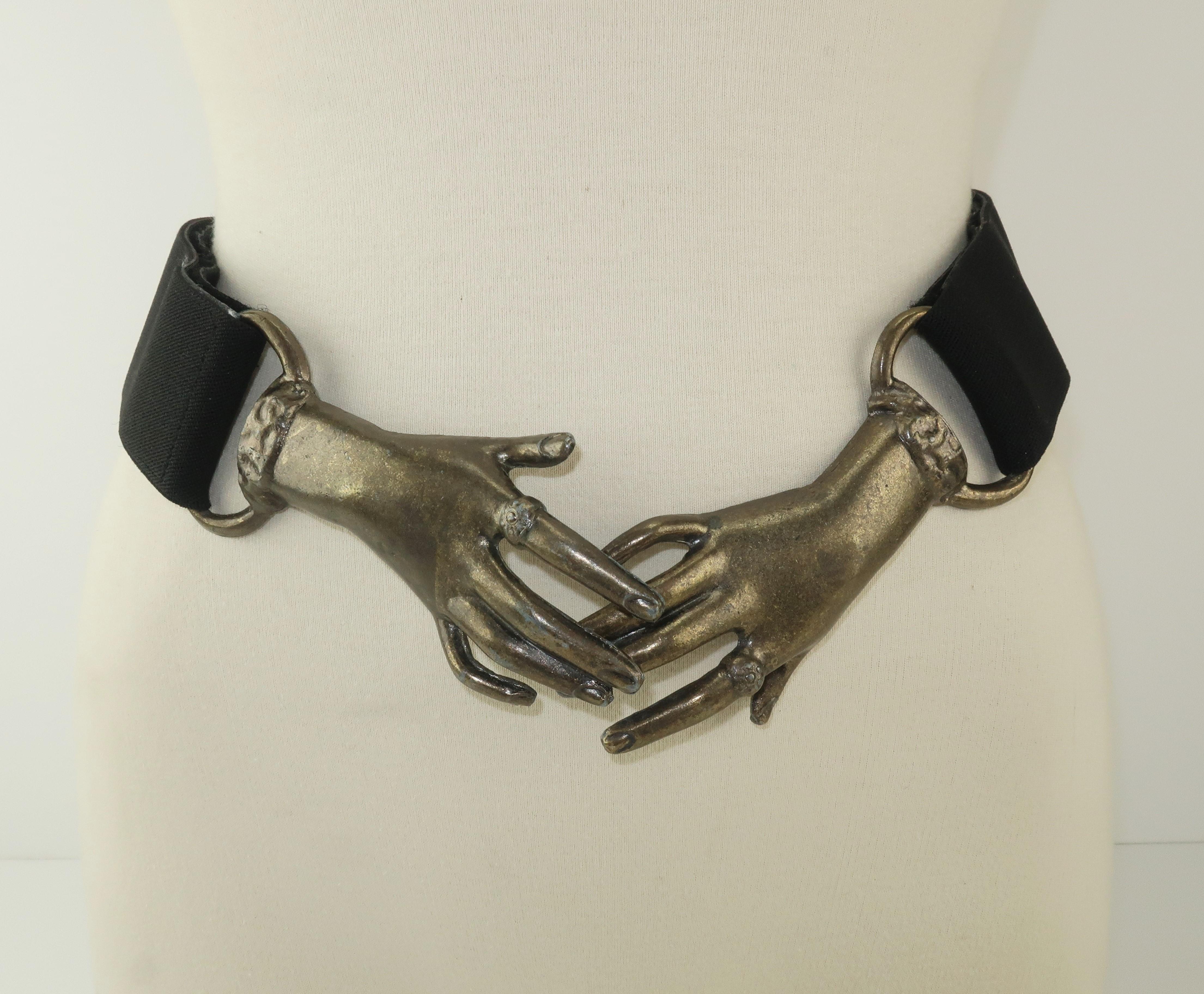 Extra hands have long been a favorite motif for fashion designers over the years including Elsa Schiaparelli.  This 1970s version depicts a pair of Victorian style clasping metal hands with an antiqued brass finish.  Each hand offers an open ended