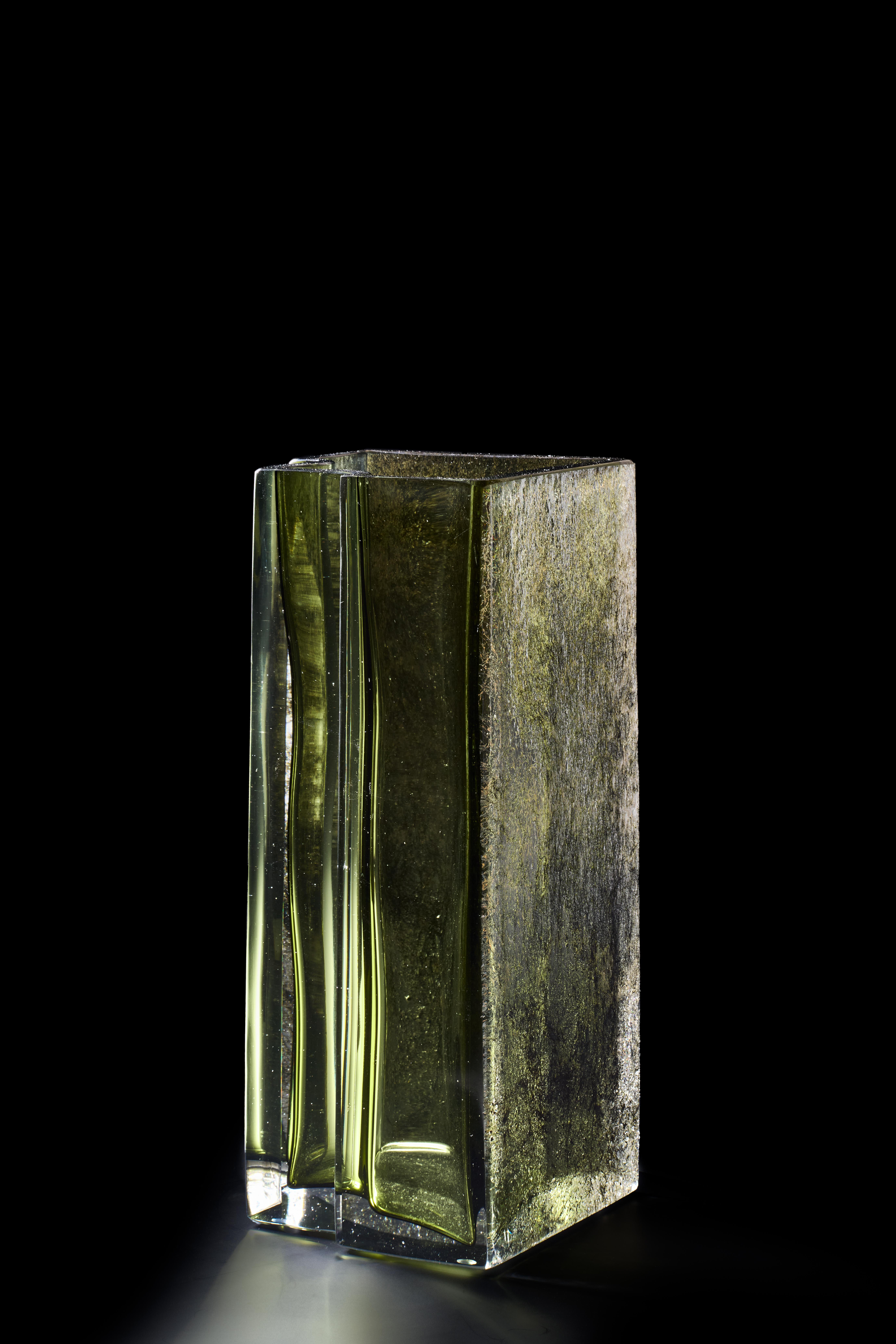 Vaso circondato da Greene & Greene di Paolo Marcolongo
Dimensioni: D 38,3 x L 16,5 x H 16 cm 
Materiali: Vetro di Murano e ferro. 


Paolo Marcolongo è nato a Padova nel 1956, ha frequentato il Liceo Artistico 