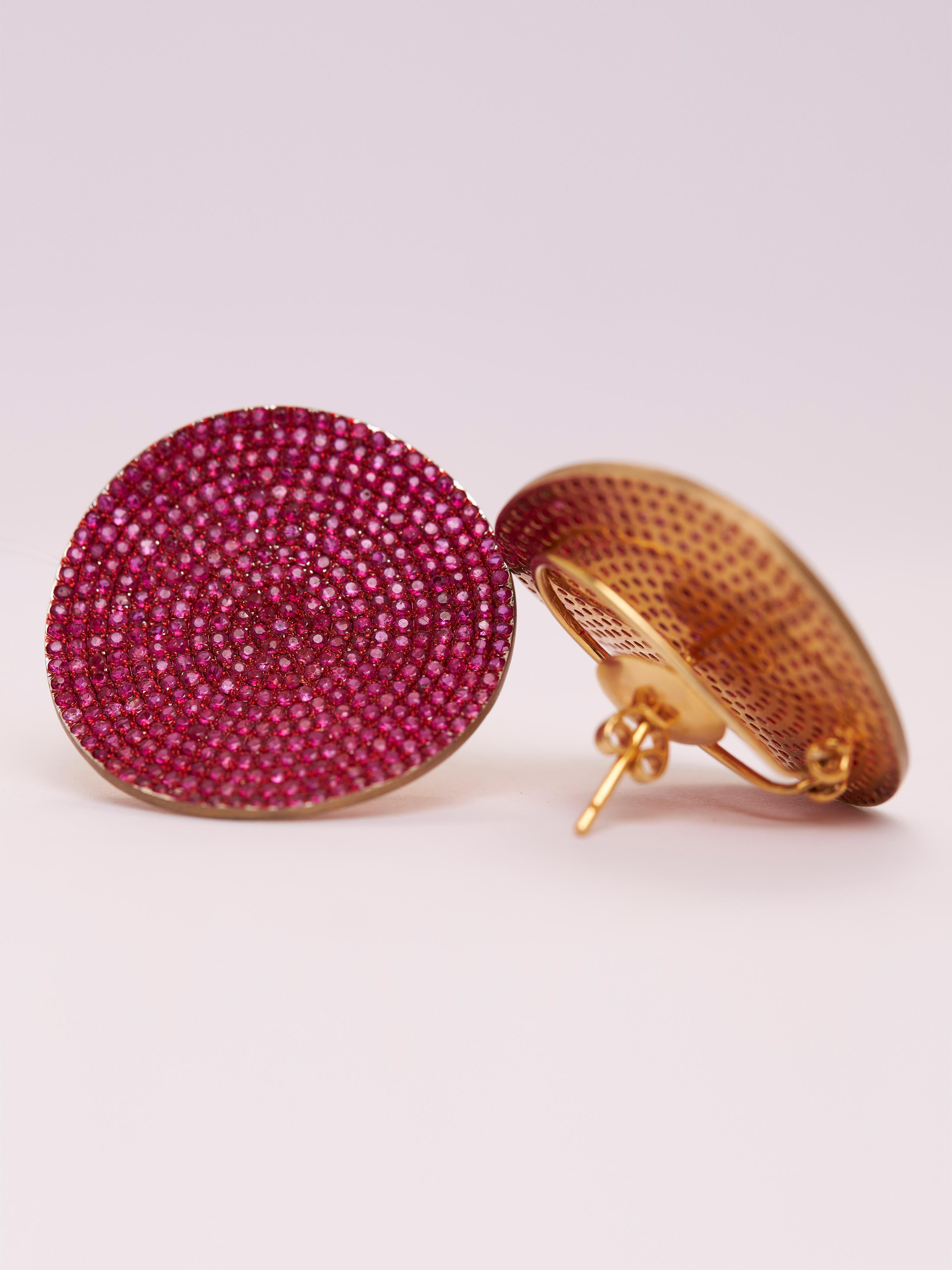 Los impresionantes pendientes en forma de disco presentan un llamativo diseño giratorio que irradia la ardiente energía de 818 rubíes (9,94 cts). Estos pendientes, elaborados en oro de 14 quilates (3,7 g) y plata (8,86 g), tienen un peso total de