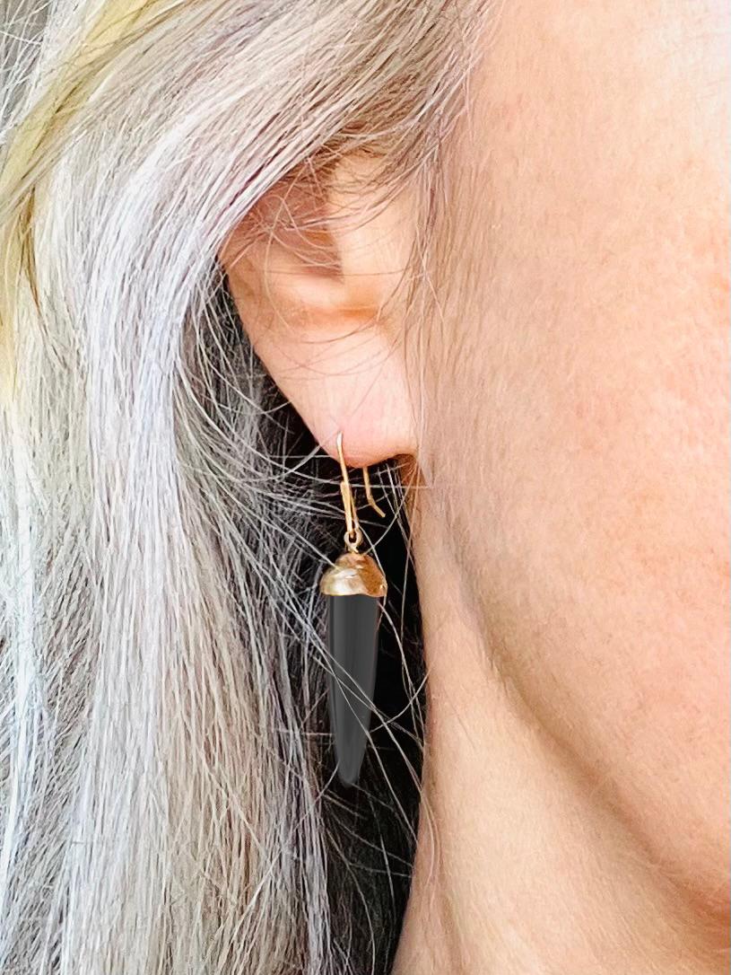 The Charcoal Black Jet and Gold Earrings are the essence of power. 

The bullet cut Jet is modern and contemporary.
The Black Cut Jet and Gold Drop Earrings feature vintage, bullet shaped Black Jet gemstones and recycled 14 Karat yellow gold. 

Jet