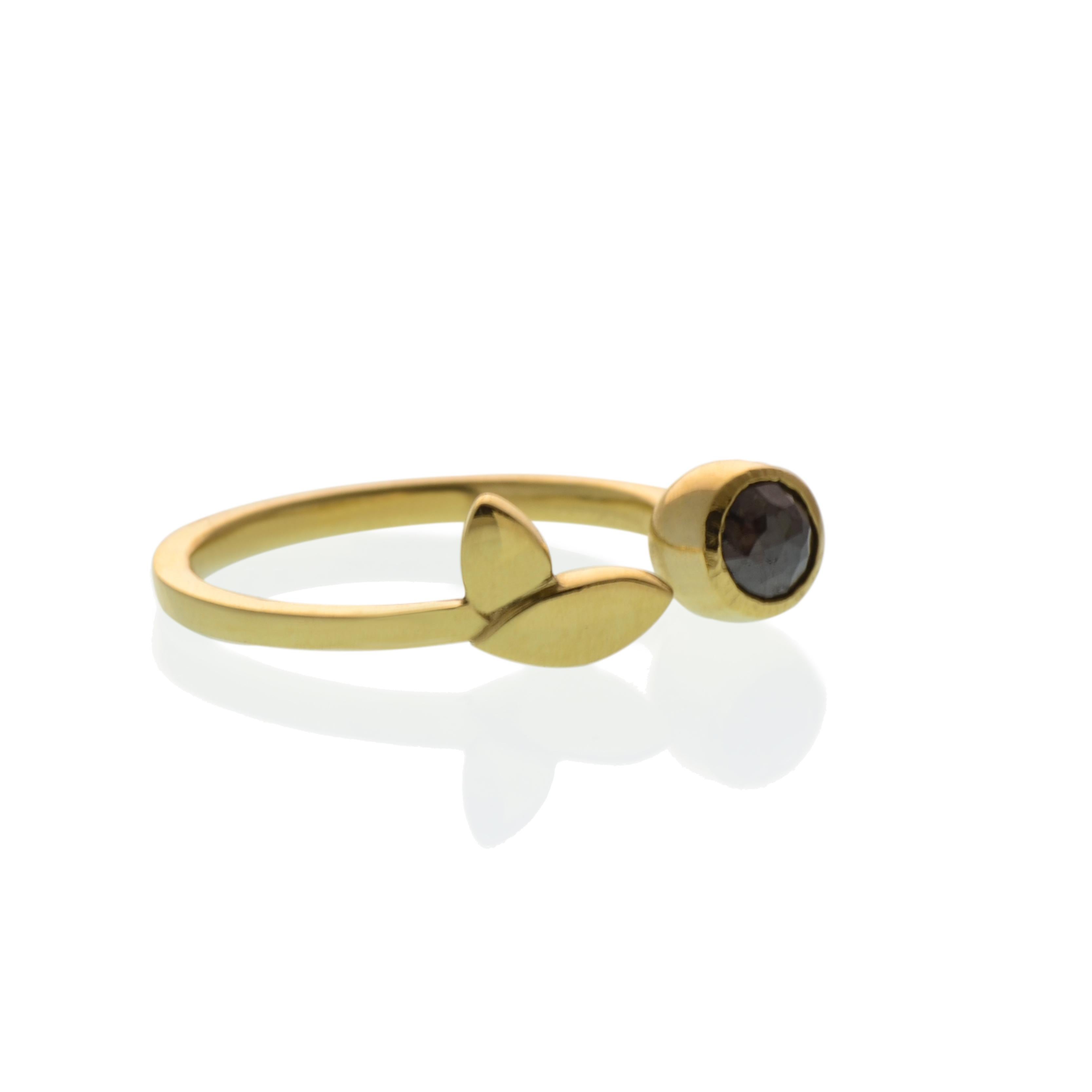 Our Gold and Black Diamond Flora Leaf Ring is reminiscent of a garden twig wrapped around your finger on a warm summer day. The diamond is a dark charcoal colored rose cut diamond surrounded by a cup of gold that is integrated into the ring. Open on