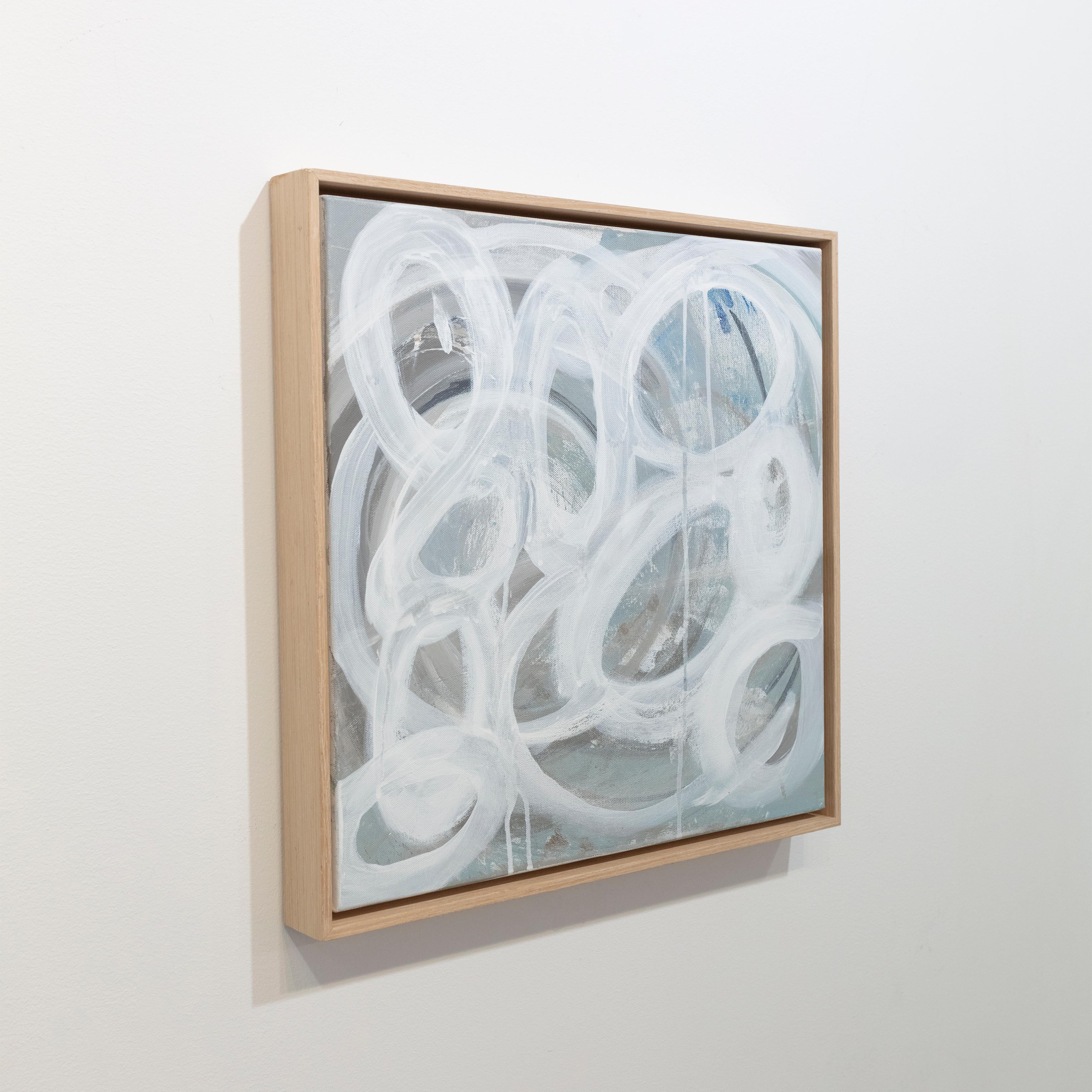 Questo quadro astratto di Sue De Chiara è realizzato con colori acrilici su tela. Presenta una tavolozza grigio-blu chiaro, con forme circolari bianche applicate con tratti leggeri e sciolti lungo la composizione. Il dipinto è incorniciato