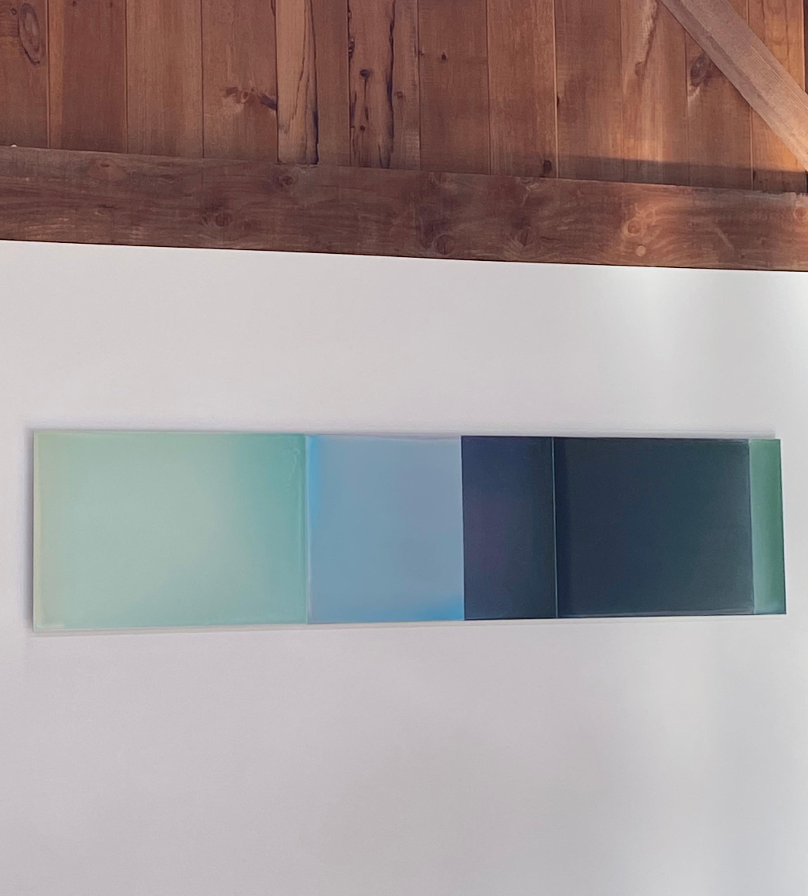 The surface of Two Stories No. 2 by Susan English is a wonderful play of color, light, and composition. Hues of soft jade, pale teal bluish green, light blue, dark indigo and dark olive green meet and merge in softly transitioning planes. The poured