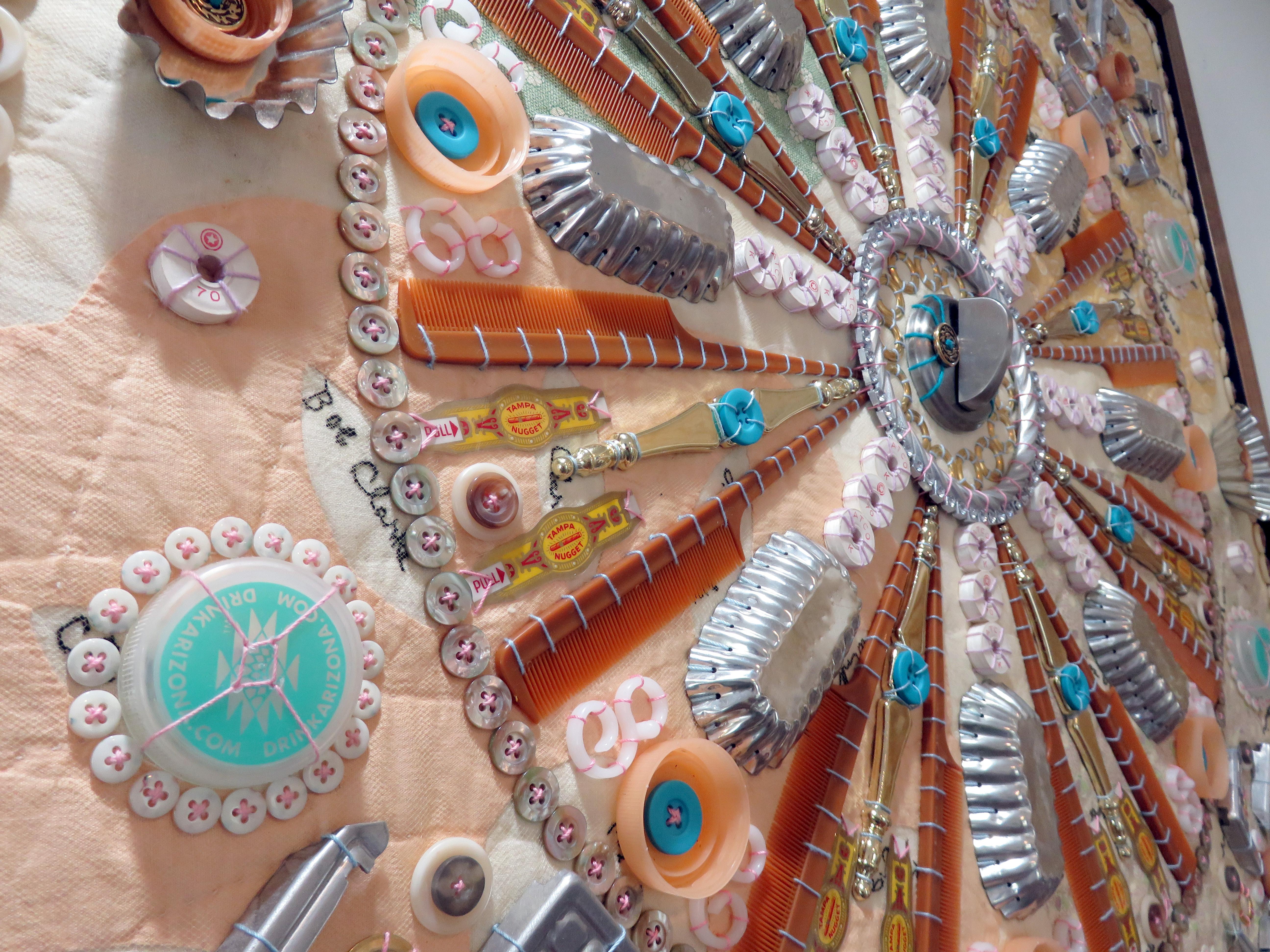 Quest'opera presenta sfumature di verde, giallo, blu e rosso.

Susan Lenz, artista di Columbia, Carolina del Sud, usa ago e filo per esprimersi. La sua serie in corso Found Objects Mandalas parla del desiderio universale di un luogo di appartenenza