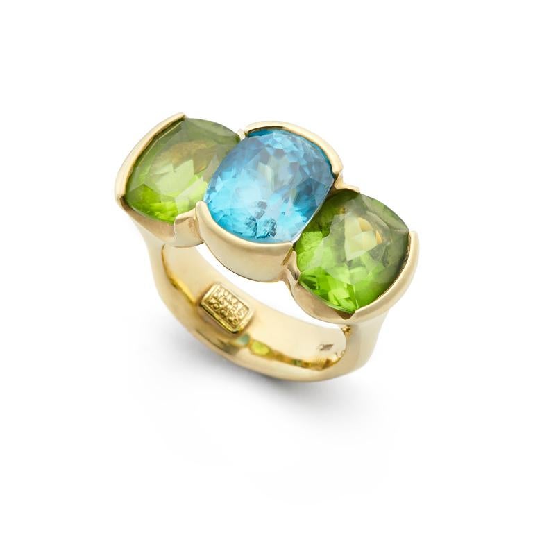 Set in 18kt Gold, this eye-catching three stone ring features a 9.20 carat Blue Zircon highlighted with 7.84 carats of Peridot.

Blue Zircon: 9.20ct; 9.5mm x 12mm       
Peridot: 7.84ct; 11mm x 9mm
