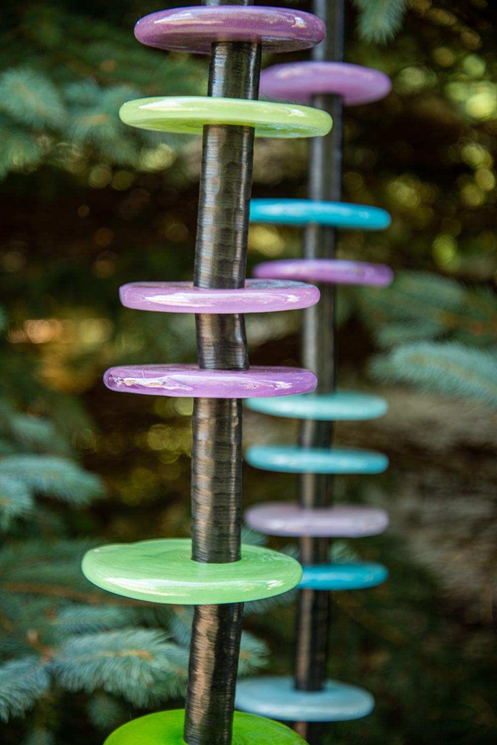 Susan Rankin’s charming outdoor columns were inspired by her love of gardening. Sunlight shines through rings of brightly coloured hand-blown glass in turquoise, lime green, purple and pink. The ‘floral’ rings are stacked organically on 5 steel