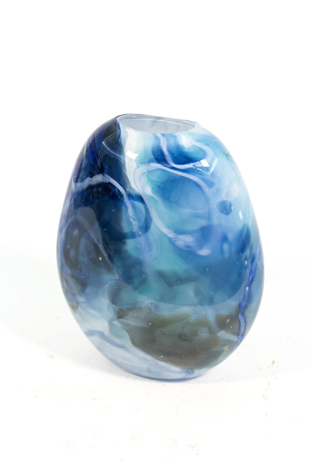 Questo bellissimo vaso blu cielo in vetro soffiato prende la sua forma organica e i suoi motivi selvaggi dalla Nature. 

L'artista canadese Susan Rankin trova ispirazione nei colori e nelle forme sempre diverse del giardino che cura per tutta