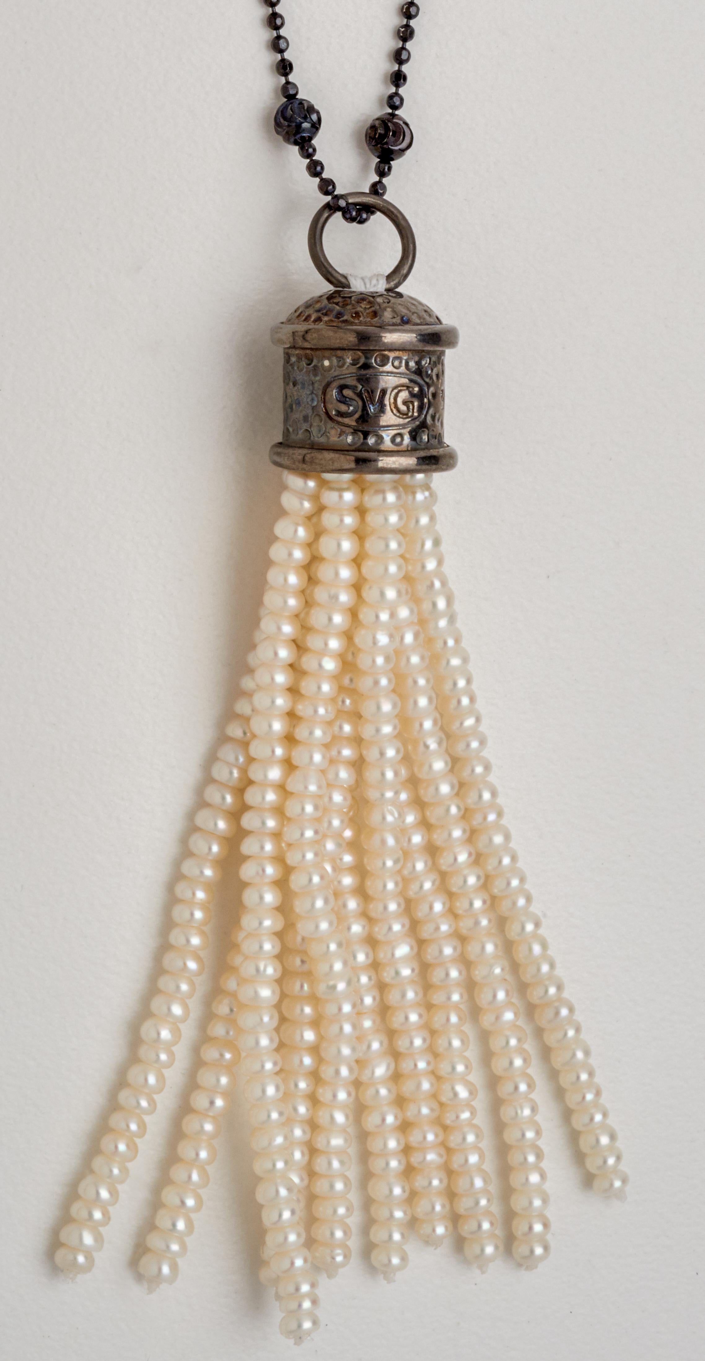 Versatile for daytime or evening wear, this contemporary pendant necklace is a constant for any jewelry collection. Crafted with a sterling silver tassel cap & over 350 hand strung 2-1/2 mm freshwater pearls. The feature pendant is displayed on an