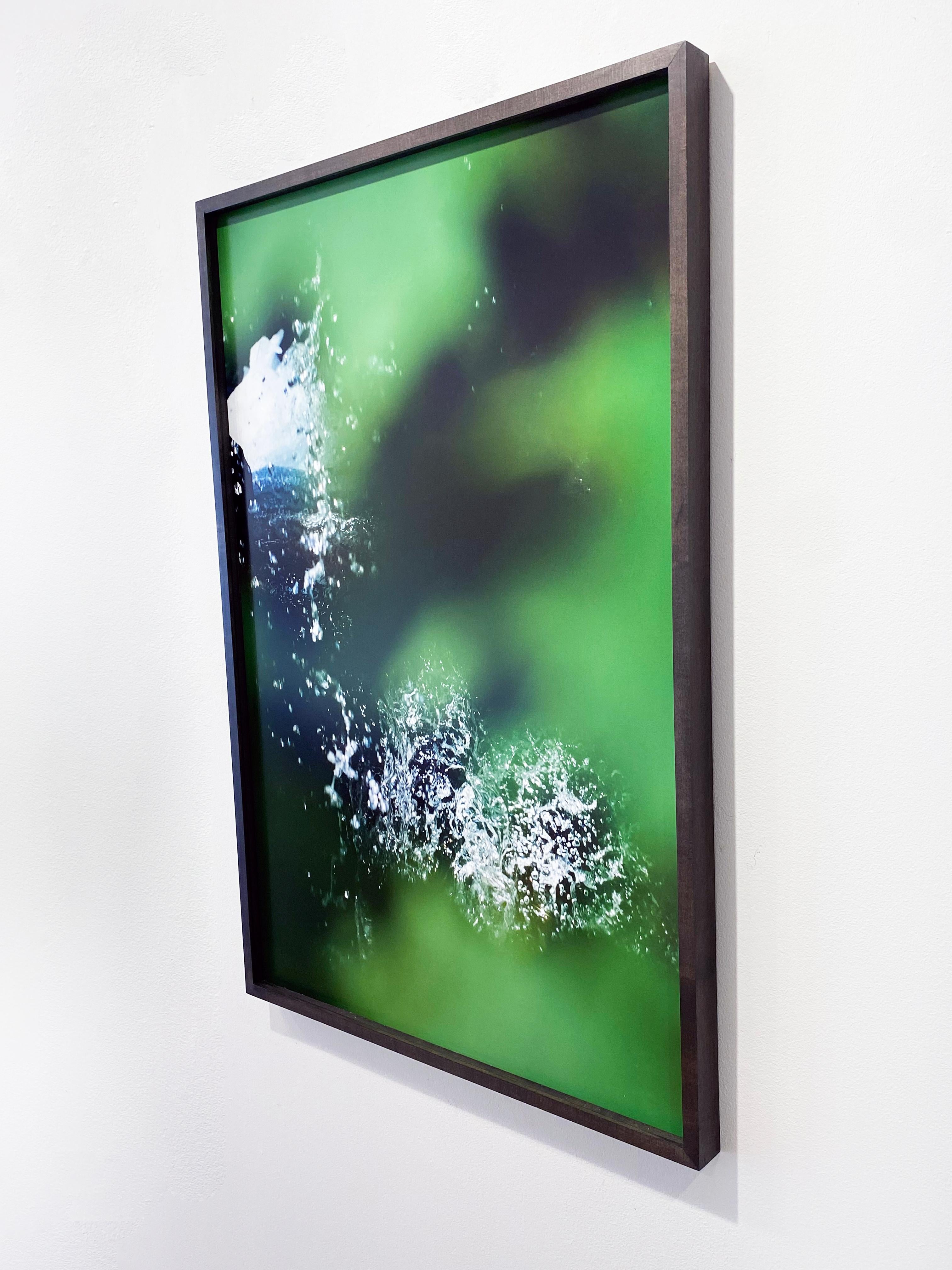 '8.8.16_1:34:49' 2020 by New York, contemporary camera artist Susan Wides. Pigmented ink print, Ed. of 5, 36 x 24 in. / Frame: 36.75 x 24.75 in. This color photograph features an abstracted view of water and leaves in a dark brown/black frame. Wides
