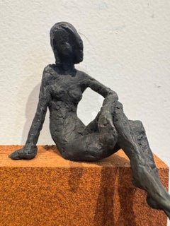 Ragazza seduta su pannello-scultura contemporanea in bronzo, nudo femminile su pannello rustico