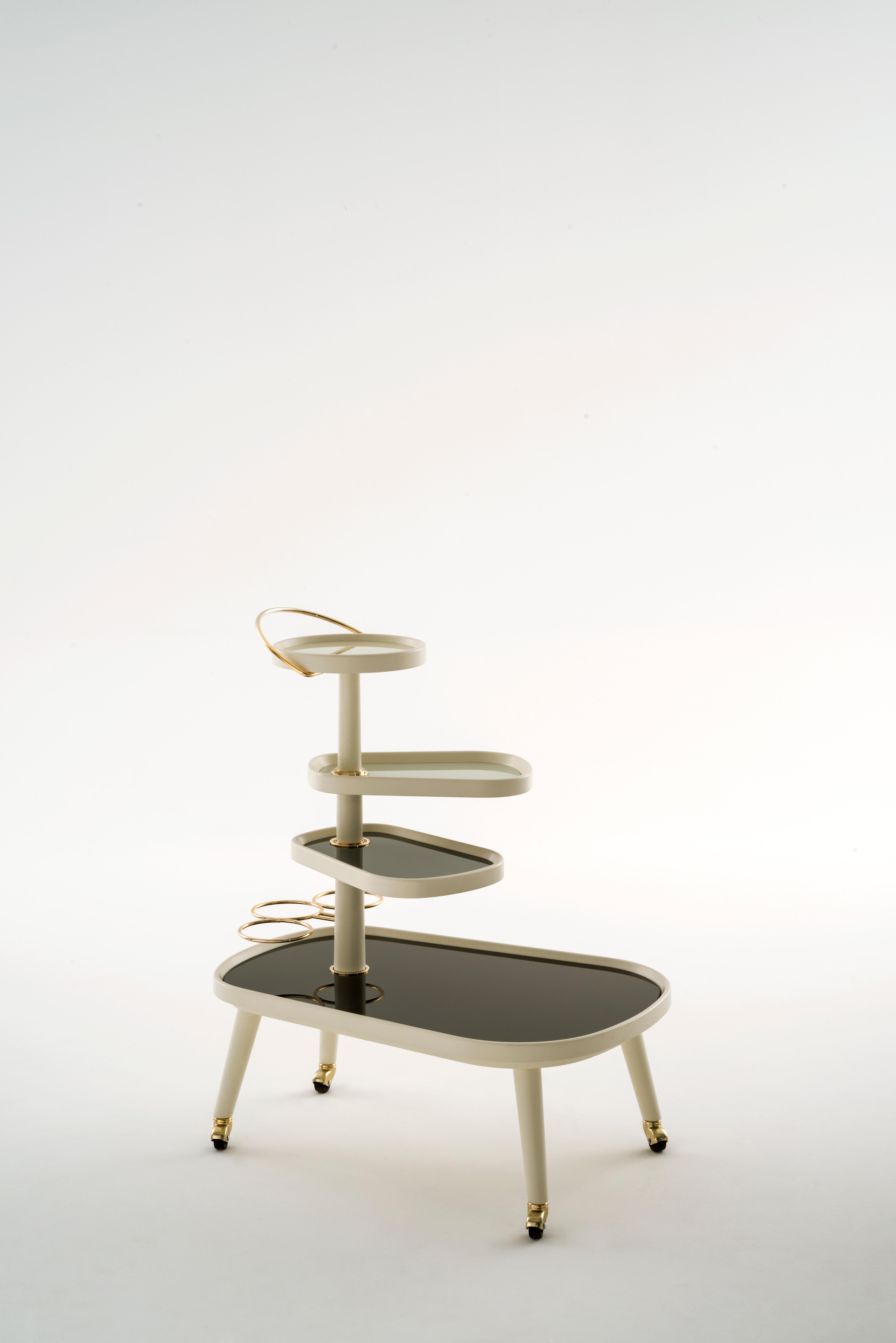 A trolley on wheels with turning shelves, a piece of furniture able to distinguish an interior decoration with a strong personality based on elegance and details. Lorenza Bozzoli confirms with such project her passion for sensual and soft shapes,