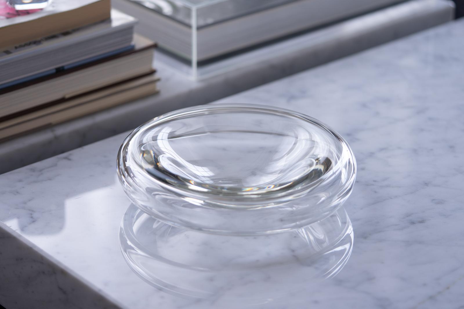 A beautifully crafted clear blown glass bowl or dish designed by father and son Alfredo & Flavio Barbini for Barbini Murano in 1972. Thick glass walls round out and downwards at its sides giving the piece the appearance of hovering above the