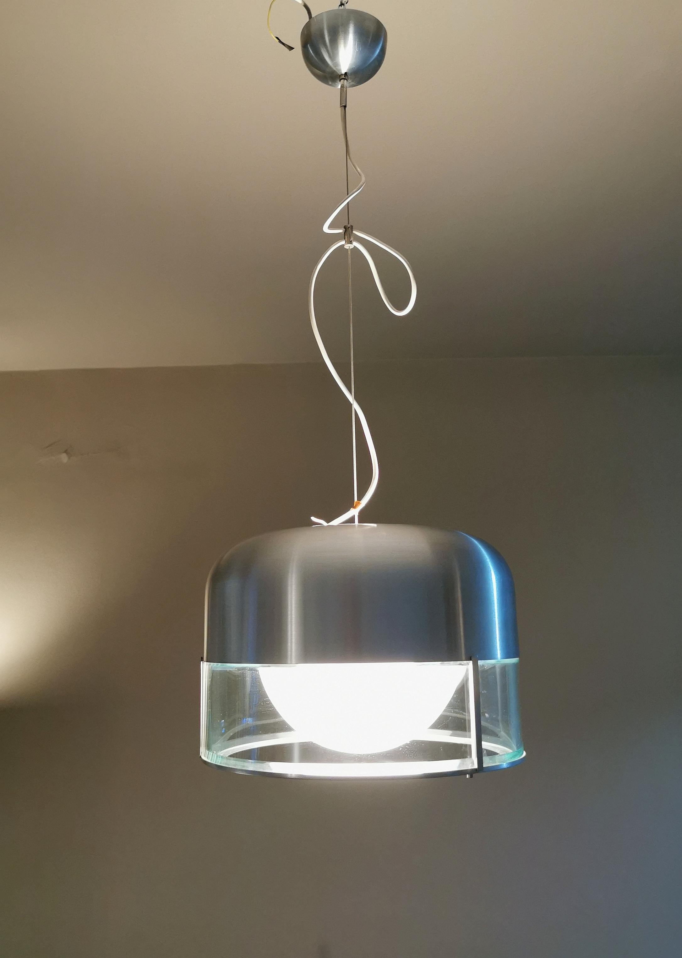 Rare suspension lamp designed by the Italian designer Pia Guidetti Crippa and produced by the Milanese company LUMI in the 70s. The lamp has a brushed aluminum structure, 3 transparent curved glasses and a white central one. It lights up both at the