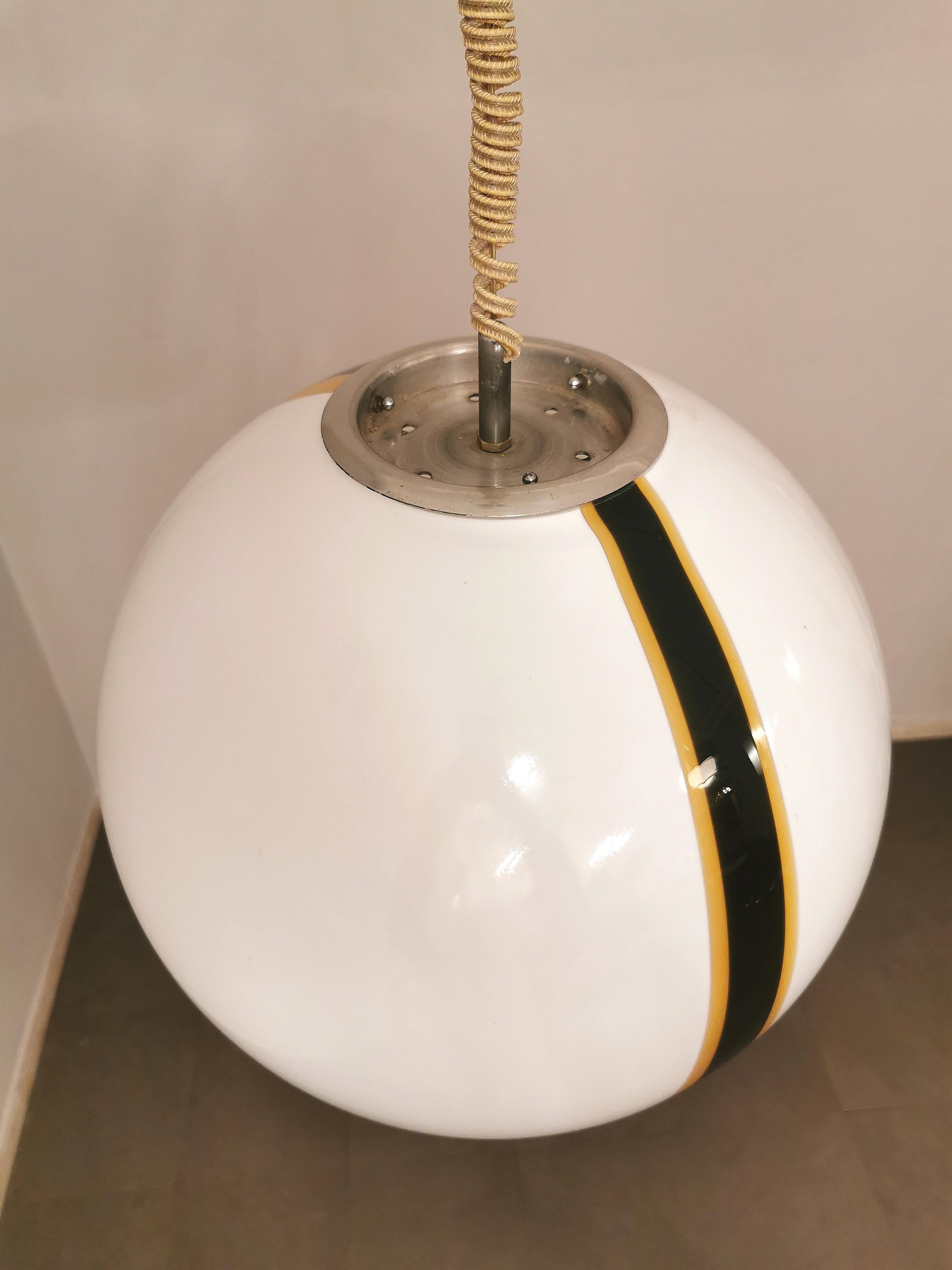 Suspension lamp attributed to the well-known Italian designer Carlo Nason with spherical bowl in white Murano glass with black and caramel-colored strip, supported by a chromed aluminum structure with 1 E27 light. The ceiling rose is in chromed