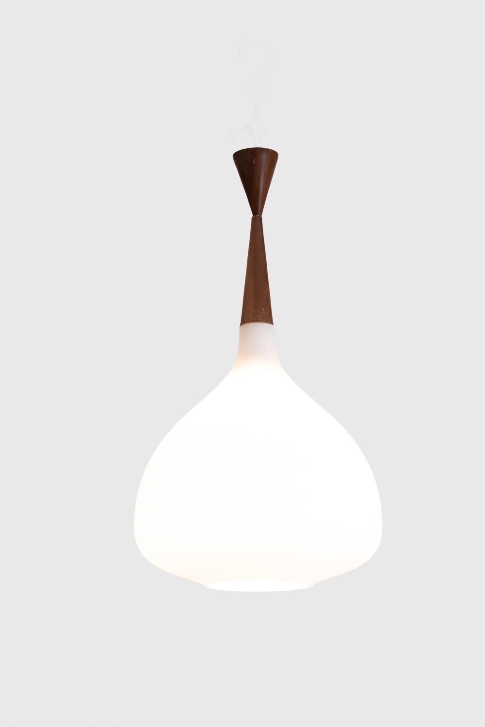 Chandelier, or suspension, in white opaline glass and blond mahogany, drop-shaped.

Danish work realized in the 1960s.

Dimensions: H 75 x D 40 cm

Reference: LS6356358M