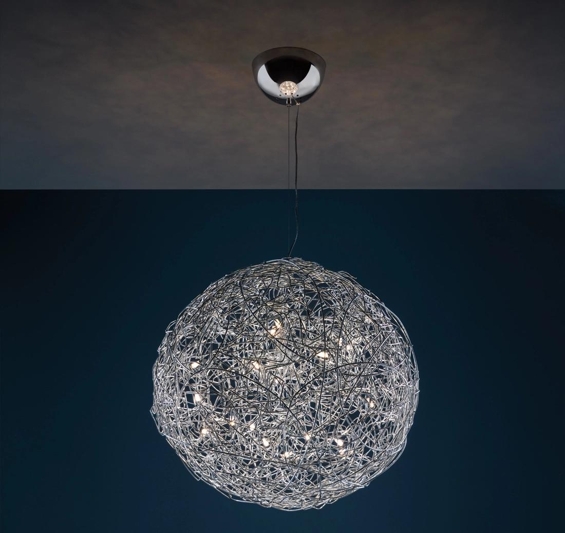 The Fil de Fer, designed by Enzo Catellani, is a signature pendant lamp made from shaped, woven aluminium wire illuminated from within. Its expansive suspended sphere creates a striking and elegant glow, enhancing the sculptural and atmospheric