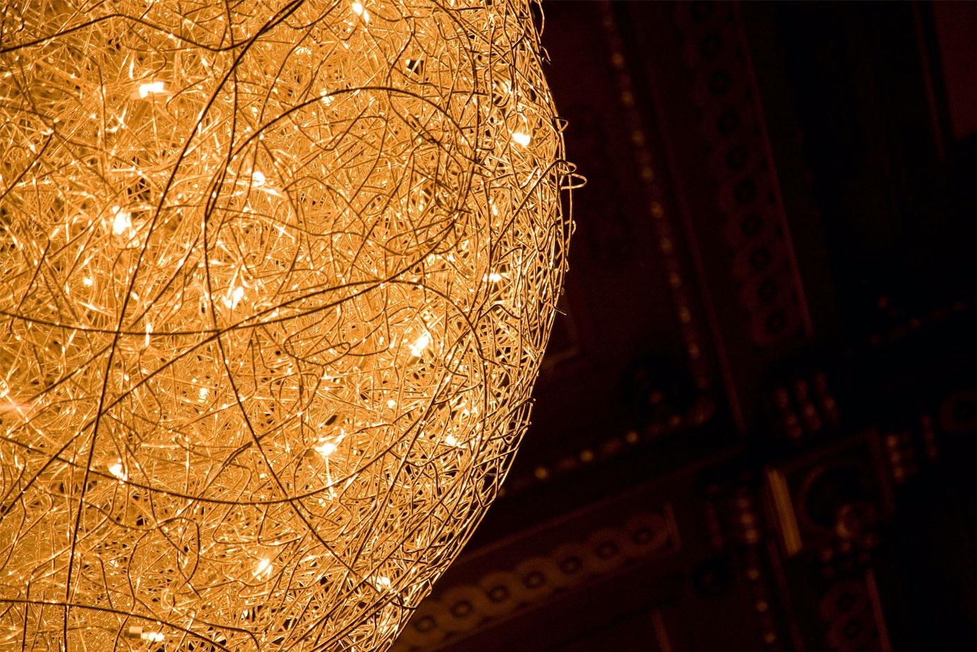 La Fil de Fer, diseñada por Enzo Catellani, es una lámpara colgante de autor fabricada con alambre de aluminio trenzado e iluminada desde dentro. Su compacta esfera suspendida emite un resplandor cálido y elegante, que realza la calidad escultórica