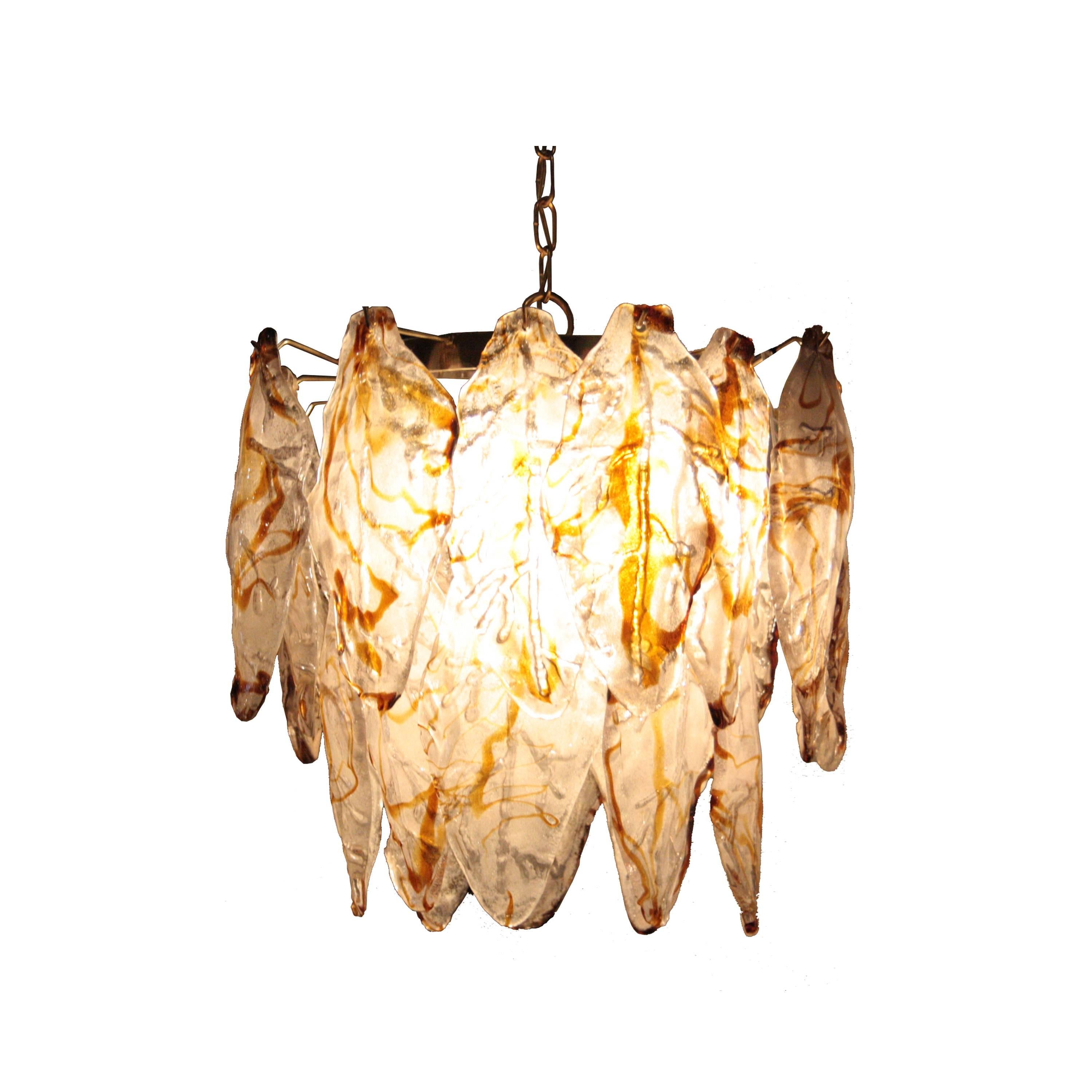 Suspension lamp with metal structure and four-light bulbs and Murano glass stones carved and handcrafted and modeled in white and brown caramel.