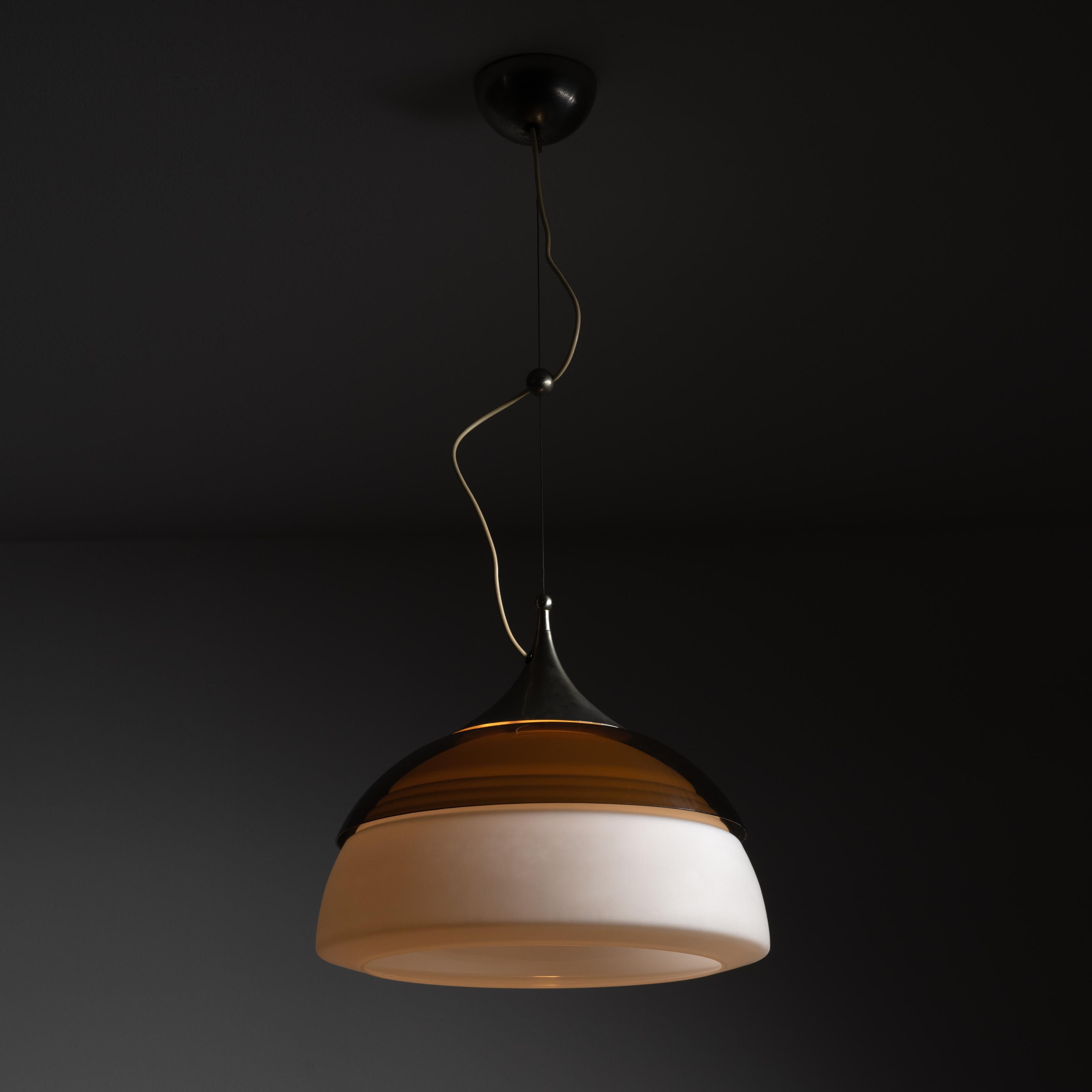Suspension lights by Stilnovo. Designed and manufactured in Italy, circa the 1960s. A whiskey colored acrylic shade stands out on this gorgeous ceiling light. At the bottom, rests a blown opal diffuser with threaded detailing at the top half. This