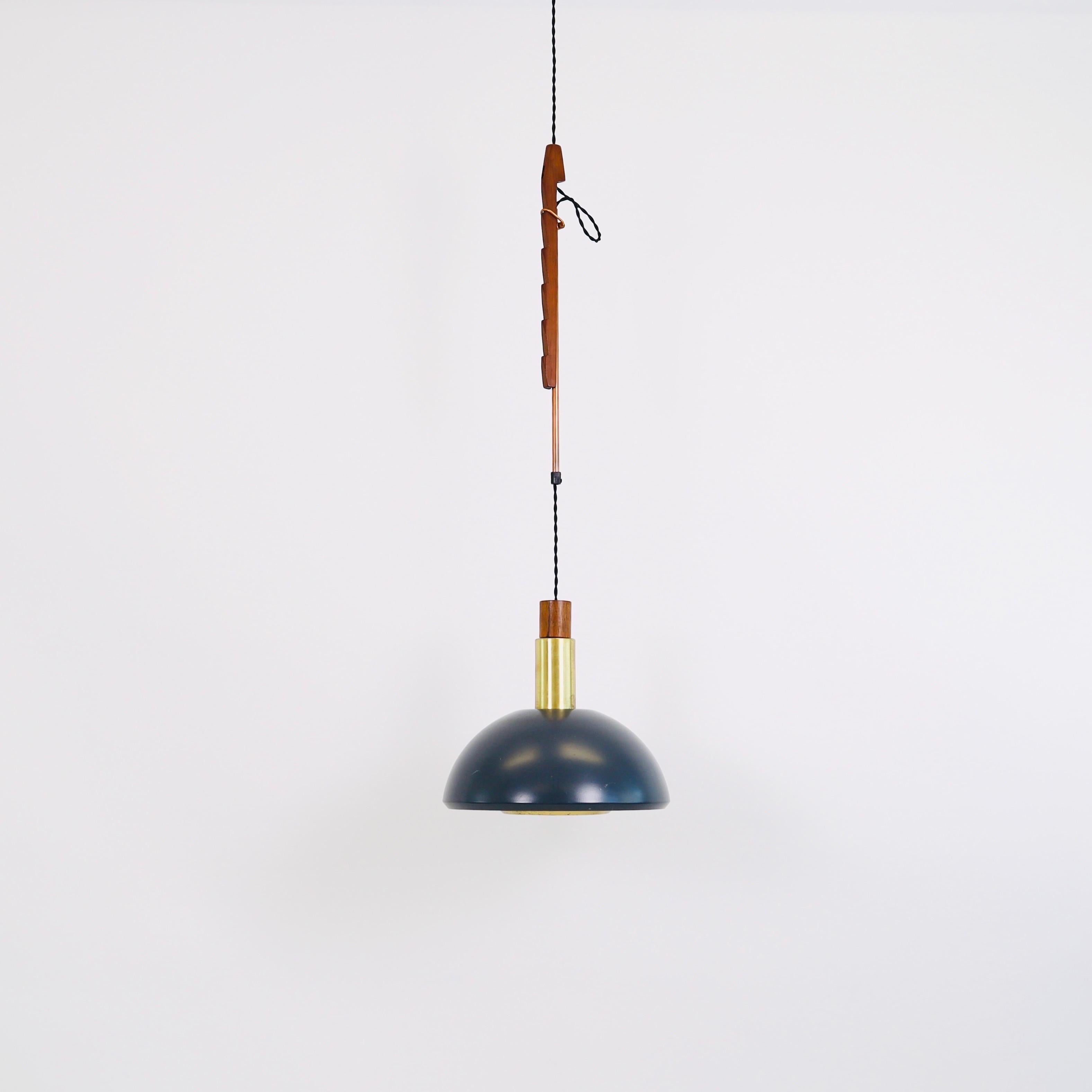 A pendant light designed Svend Aage Holm Sørensen in the 1960s. This rare piece with its teak wood suspension is a trademark of the Danish designer. 

* A gray metal pendant light with brass and teak-wood details and suspension in teak-wood allowing