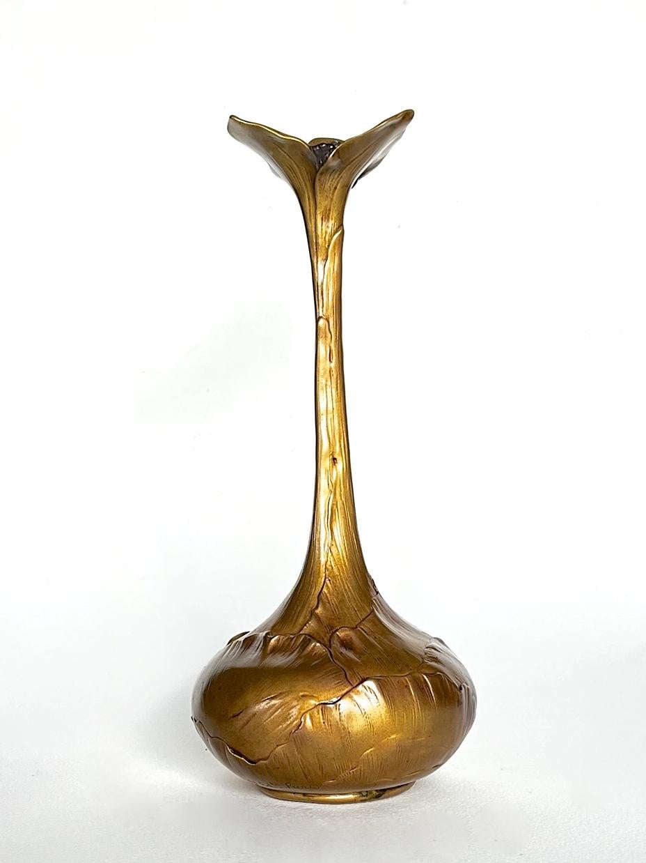 Eine elegante Vase aus vergoldeter Bronze, die die Form einer sprießenden Zwiebel hat. Der Körper ist als geschichtete Zwiebel mit einem verlängerten Hals dargestellt, der sich zu einem ti-lobed Rand öffnet, der gegossen und kalt bemalt wurde, um