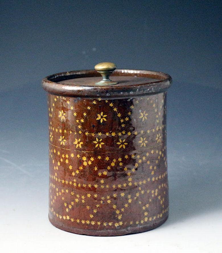 Earthenware slipware jar decorated with flower heads within a band and a profusion of stars in geometric patterns the piece with the initials S S and the date August 31st 1810 also in slip decoration. The metal lid is a tinker 