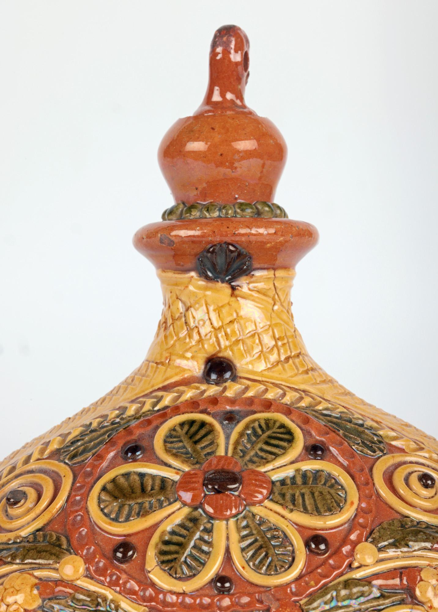 A very stylish and hand crafted slipware pottery pilgrim flask decorated with floral designs probably originating from Sussex, England and dating to the 19th century. The lightly potted flask made from red terracotta earthenware is of large round