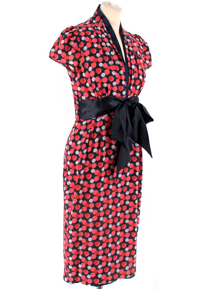 Suzannah Pink Spotted Silk Dress 
- Navy dress with pink and red spot pattern
- Navy ribbon around collar and sash around waist
- Fully lined
- Short capped sleeves
- Cross over detail at the back of the dress
- low cut v neck

Materials
100%