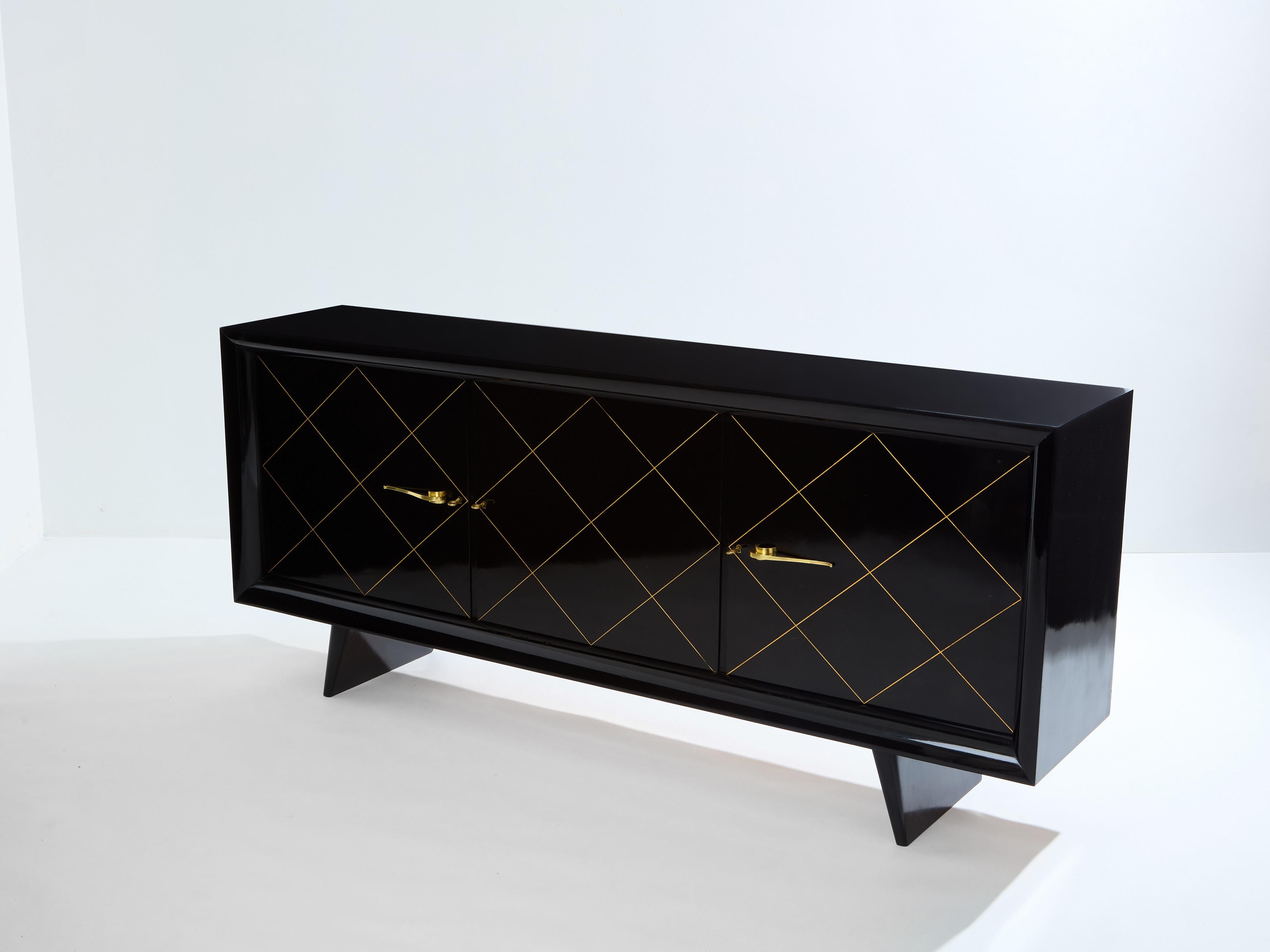 This beautiful ebonized sycamore sideboard was designed and crafted by Suzanne Guiguichon in the early 1940s. It features three doors, each with gilt geometric lines, opening with brass handles and keys, and revealing two shelves on the central