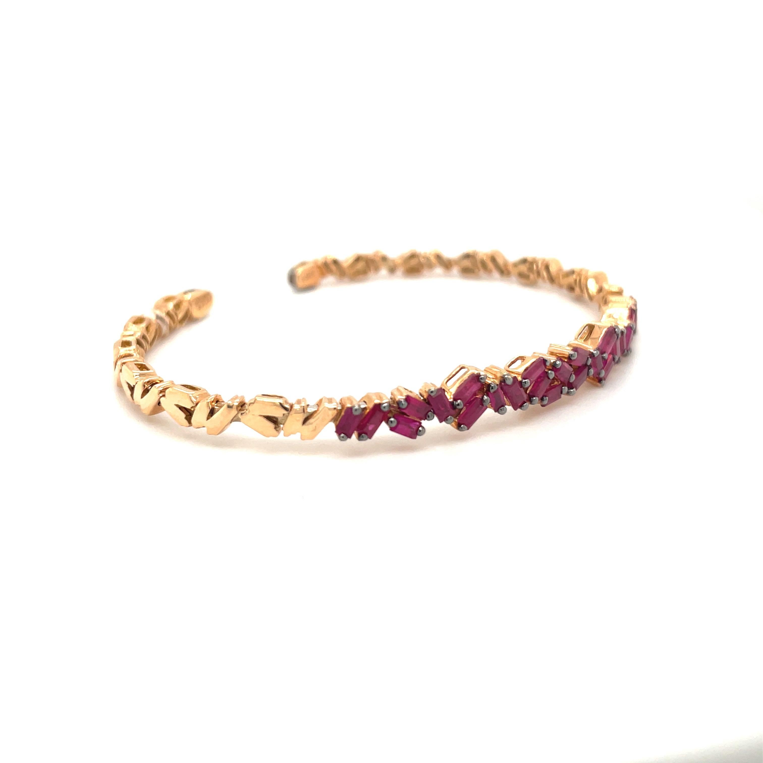 Twenty six beautiful ruby baguettes adorn this unique 18 karat white gold flexible bangle by Susanne Kalan. 
Rubies = 1.80cts 