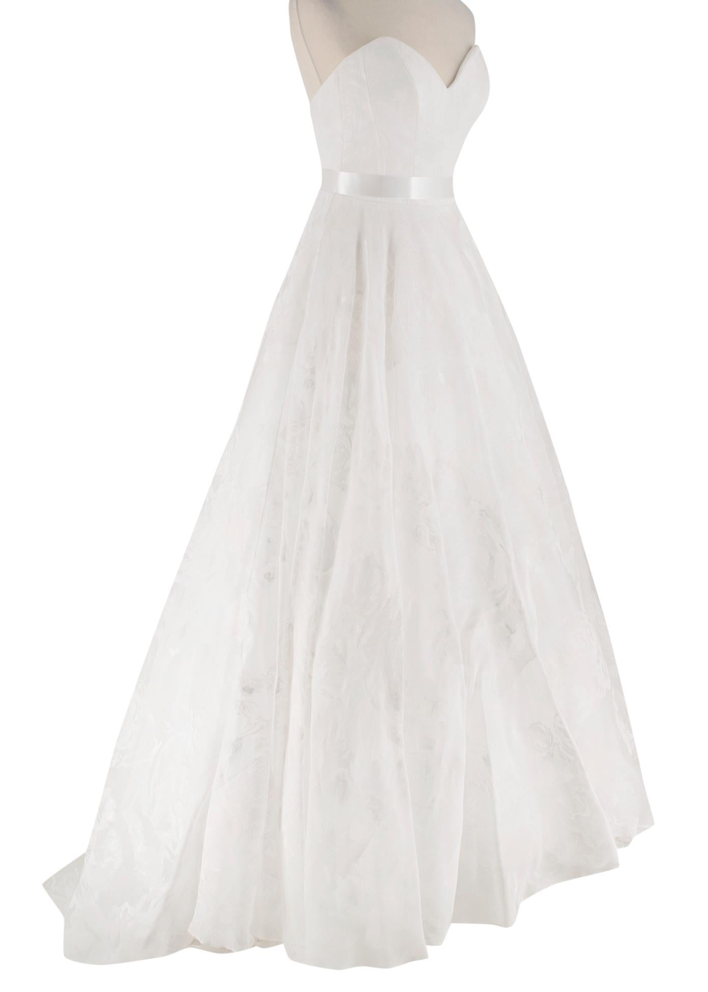 Suzanne Neville Cabianca Ivory Silk Organza Wedding Dress

A-line Style with a full organza skirt
Sweetheart Neckline
Low Back
Strapless
Floral Pattern throughout
Corseted back with button closure
Silk Satin Waistband
Dust Bag included
Freshly Dry