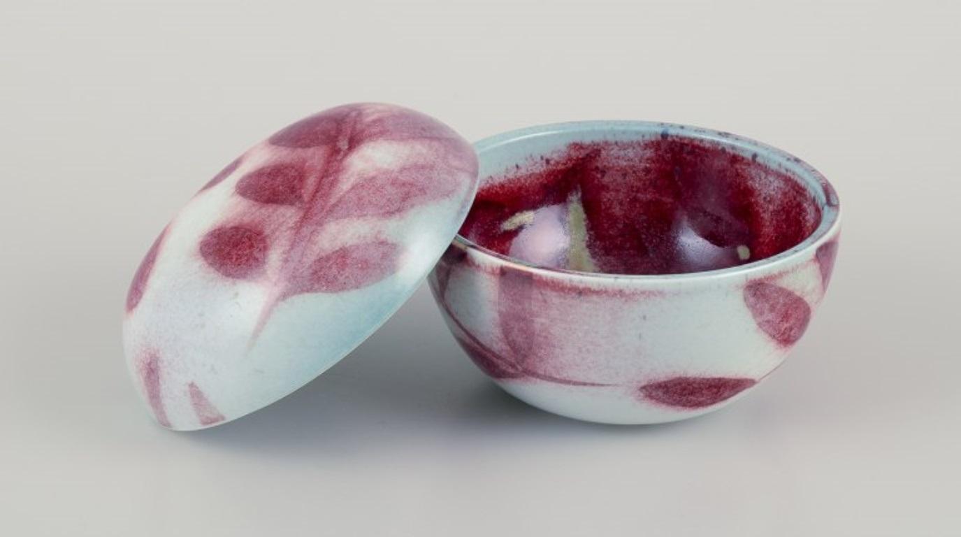 Suzanne Öhlén (nata nel 1953) per Rörstrand, Svezia.
Unico vaso con coperchio in ceramica decorato con motivi di foglie.
Smalto color borgogna su base chiara.
1980s.
Contrassegnato.
Condizioni perfette.
Dimensioni: D. 11,0 cm x H. 9,5 cm.