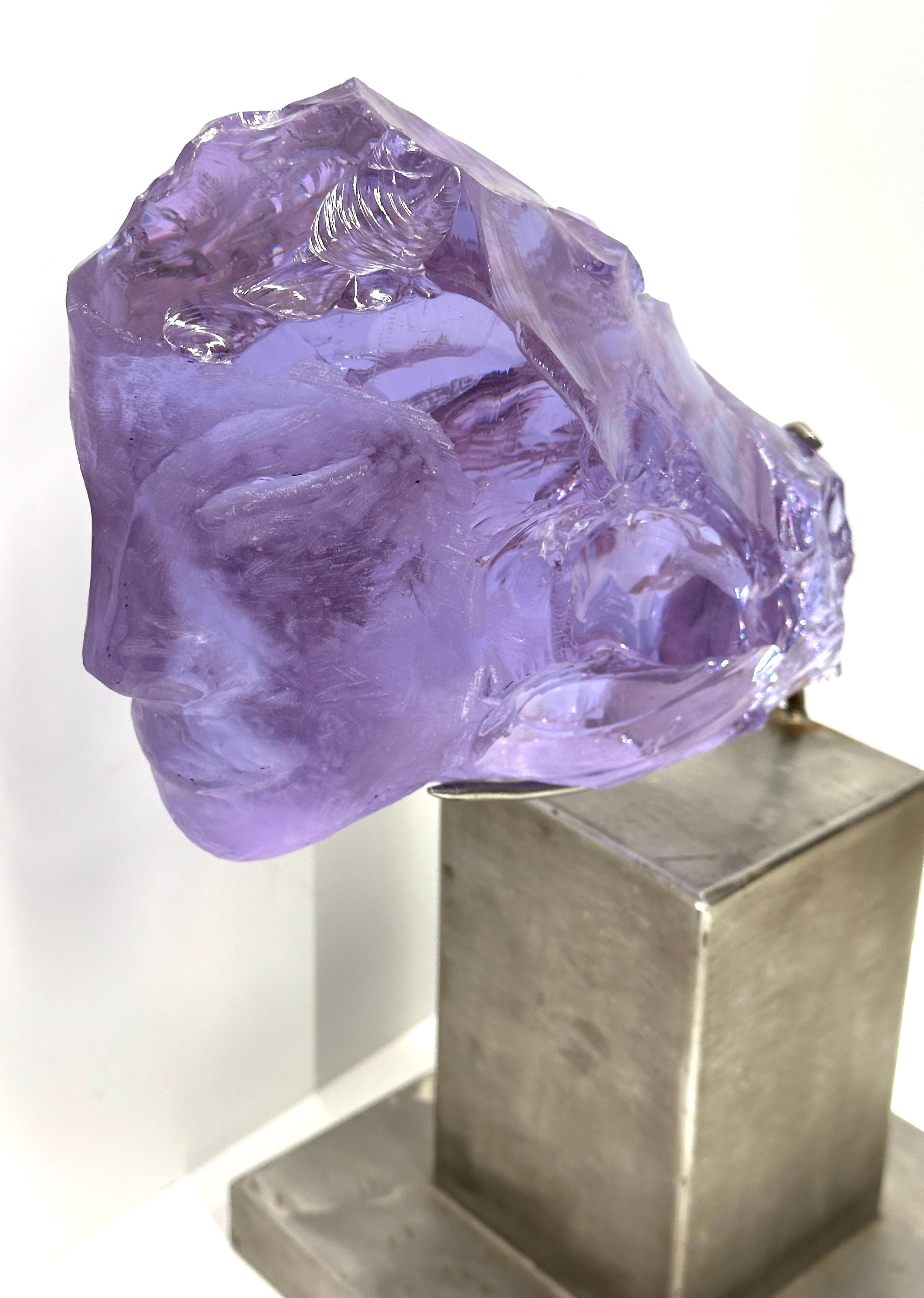 A stunning purple slag glass sculpture by the noted artist Suzanne Regan Pascal. It is mounted on a steel base and measures over 15 inches in height. The artist is in many important private collections, and her technique in carving slag glass was a