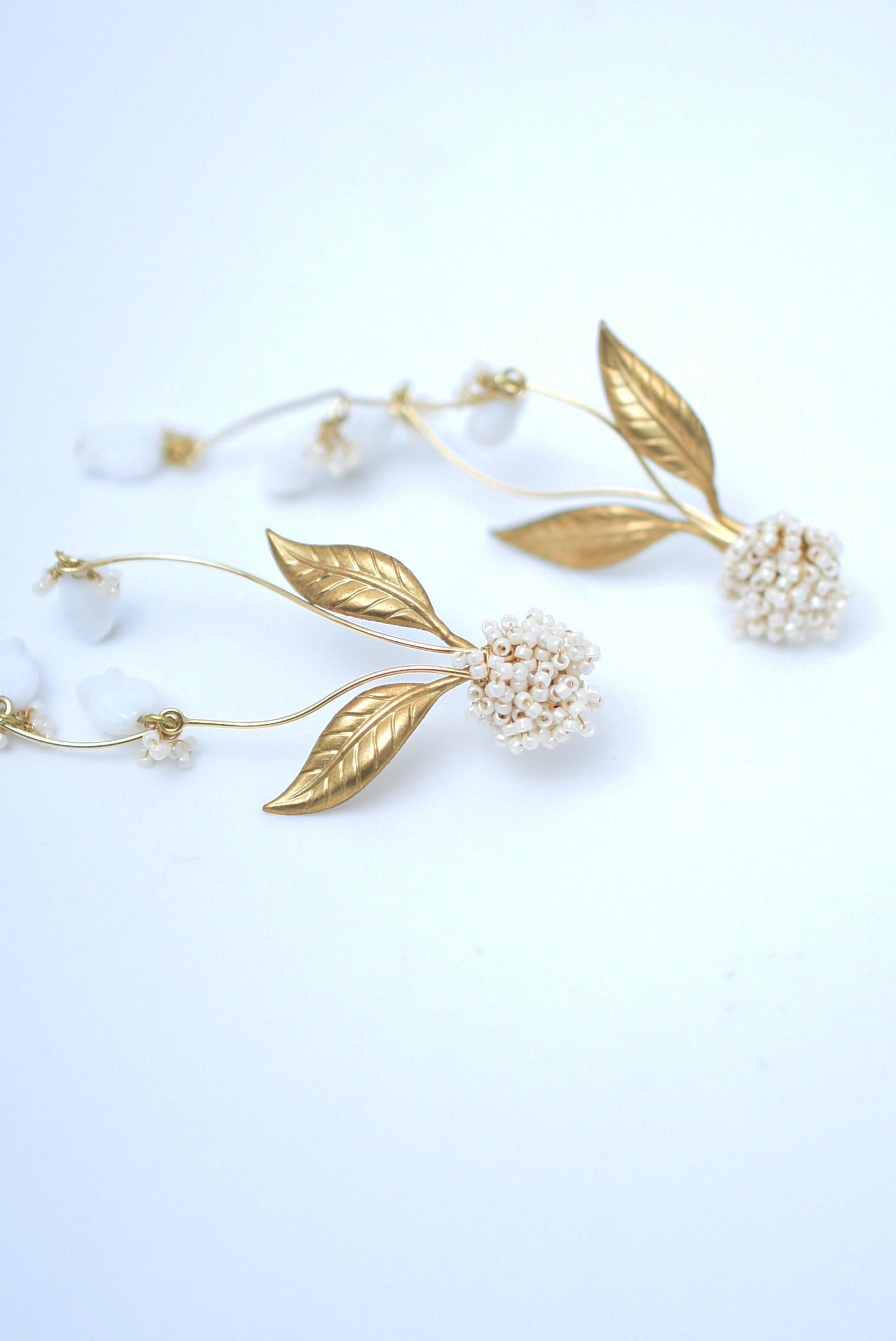 material:brass,1940's Garmany vintage glass parts,,glass beads,stainless
size:length 9cm

The beige colour of the beads emphasises the whiteness of the lily and makes it look more neat and clean.
The small, swaying lily is very pretty and perfect