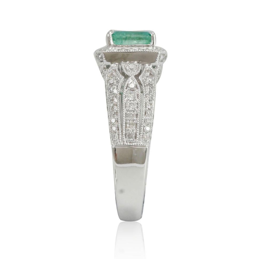 This spectacular ring from the Suzy Levian Limited Edition collection features a Colombian emerald gemstone held in a square shaped 14K white gold prong setting. An array of 138 side white diamonds (.83ct) with hand-carver French filigree work