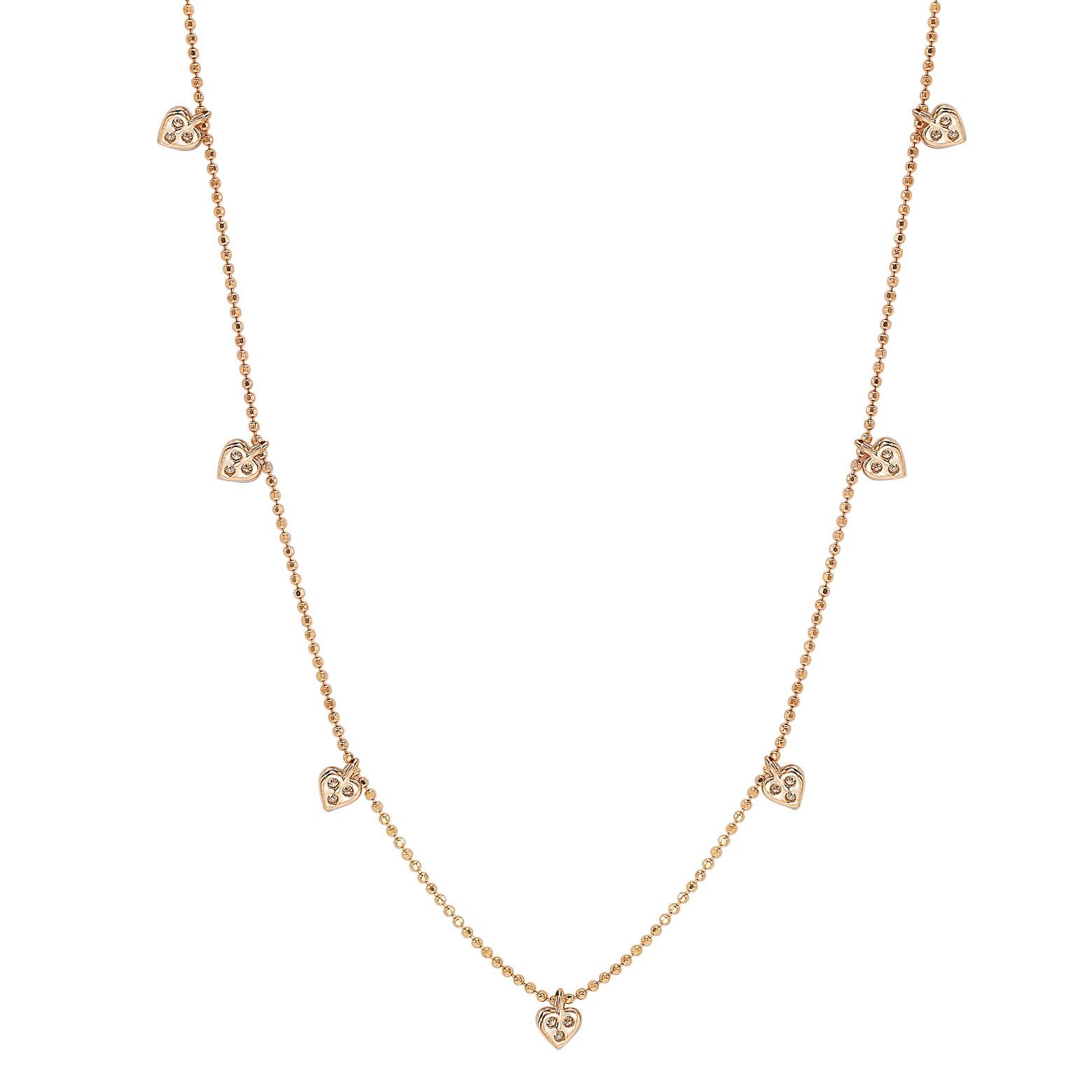 This unique Suzy Levian diamond station heart necklace displays round-cut diamonds on 14 karat rose gold setting. This gorgeous necklace contains 21 white round cut diamonds totaling .26cttw. The necklace has 7 hearts, each heart contains 3 diamond