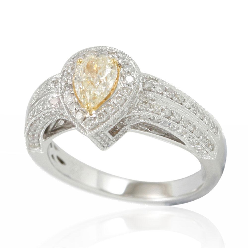 This spectacular ring from the Suzy Levian collection features a 14k two-tone white and yellow gold setting with a pear-cut, yellow diamond center stone (.65ct) . An array of white diamonds (.92cttw) accent the perfect two-tone gold setting of the