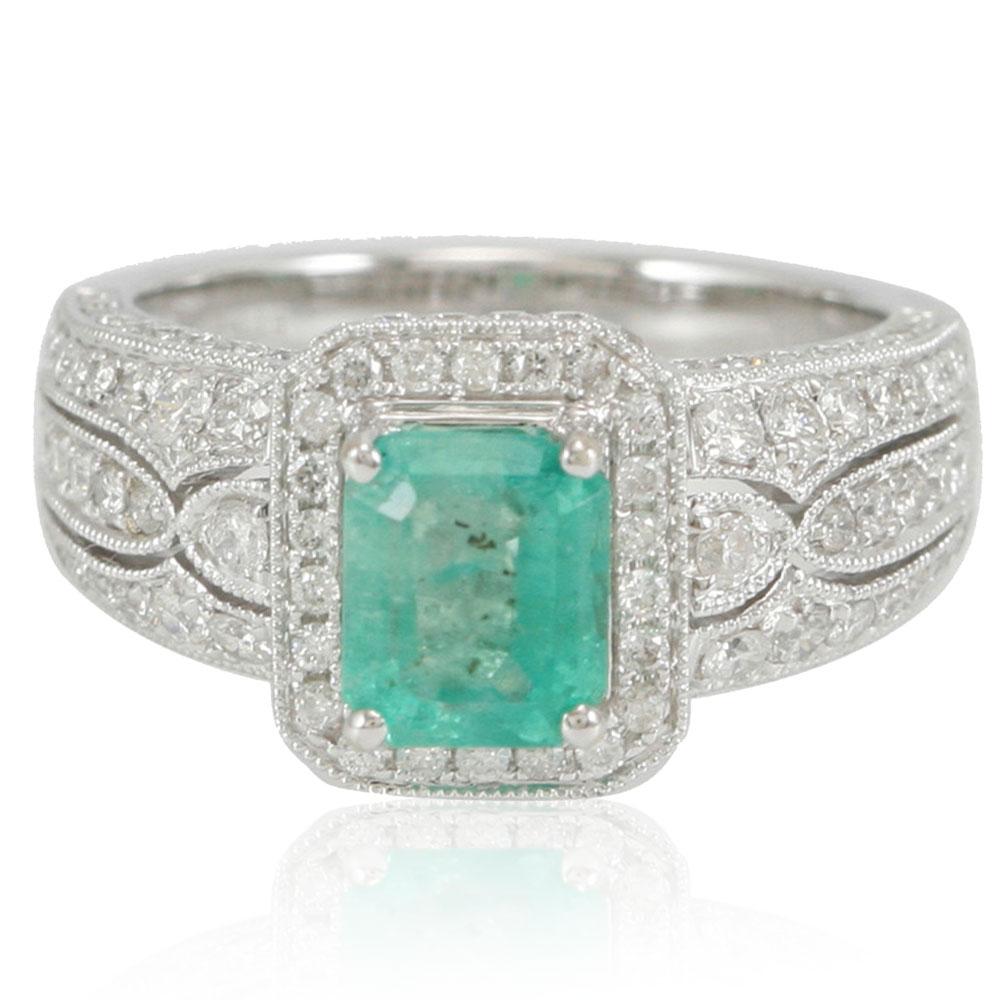 This spectacular ring from the Suzy Levian Limited Edition collection features a Colombian emerald gemstone held in a square shaped 14K white gold prong setting. An array of side white diamonds (1.09ct) with hand-carved French filigree work across