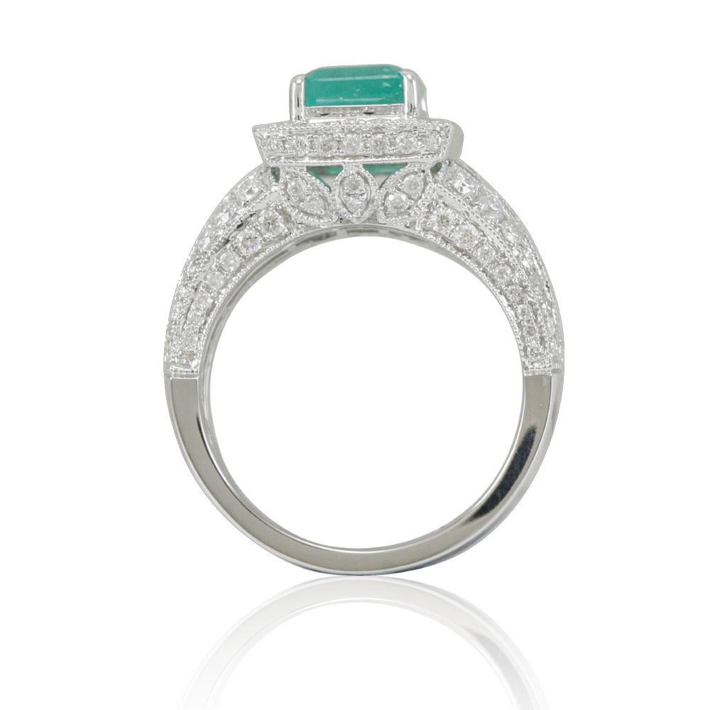This spectacular ring from the Suzy Levian Limited Edition collection features a Colombian emerald gemstone held in an elongated emerald-shaped 14K white gold prong setting. An array of 127 side white diamonds (1.07ct) with hand-carved French