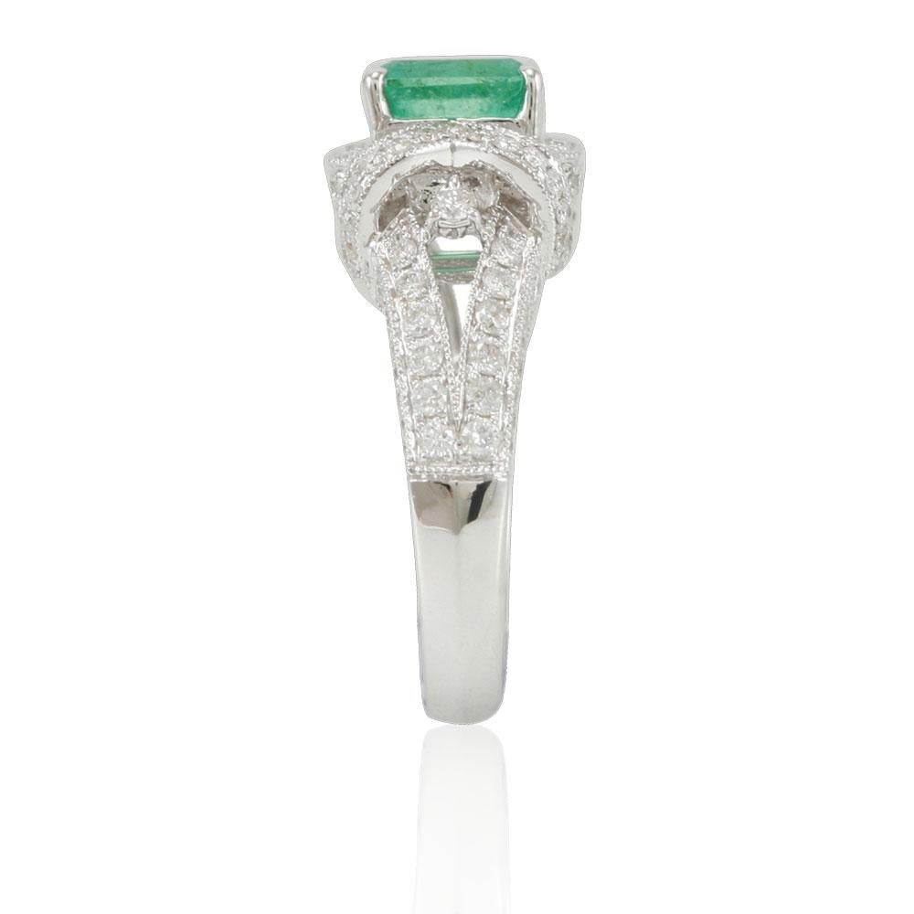 This spectacular ring from the Suzy Levian collection features a Colombian emerald gemstone held in a 14K white gold prong setting. An array of 124 side white diamonds (.91ct) with hand-carved French filigree work across the band, accents the